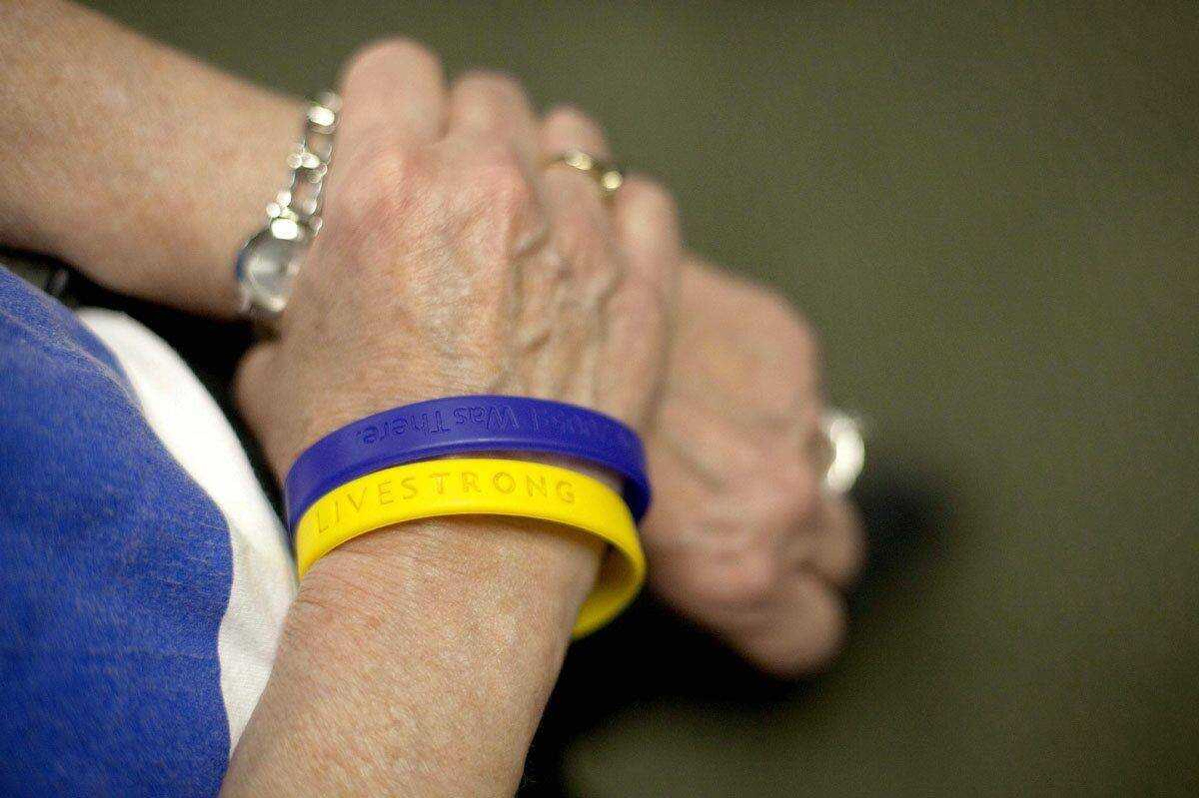 Motivational bracelets are seen April 25 on the wrist of cancer survivor Susan Morris, 65, of Decatur, Ga., as she talks with her exercise group after a class, in Atlanta. (David Goldman ~ Associated Press)