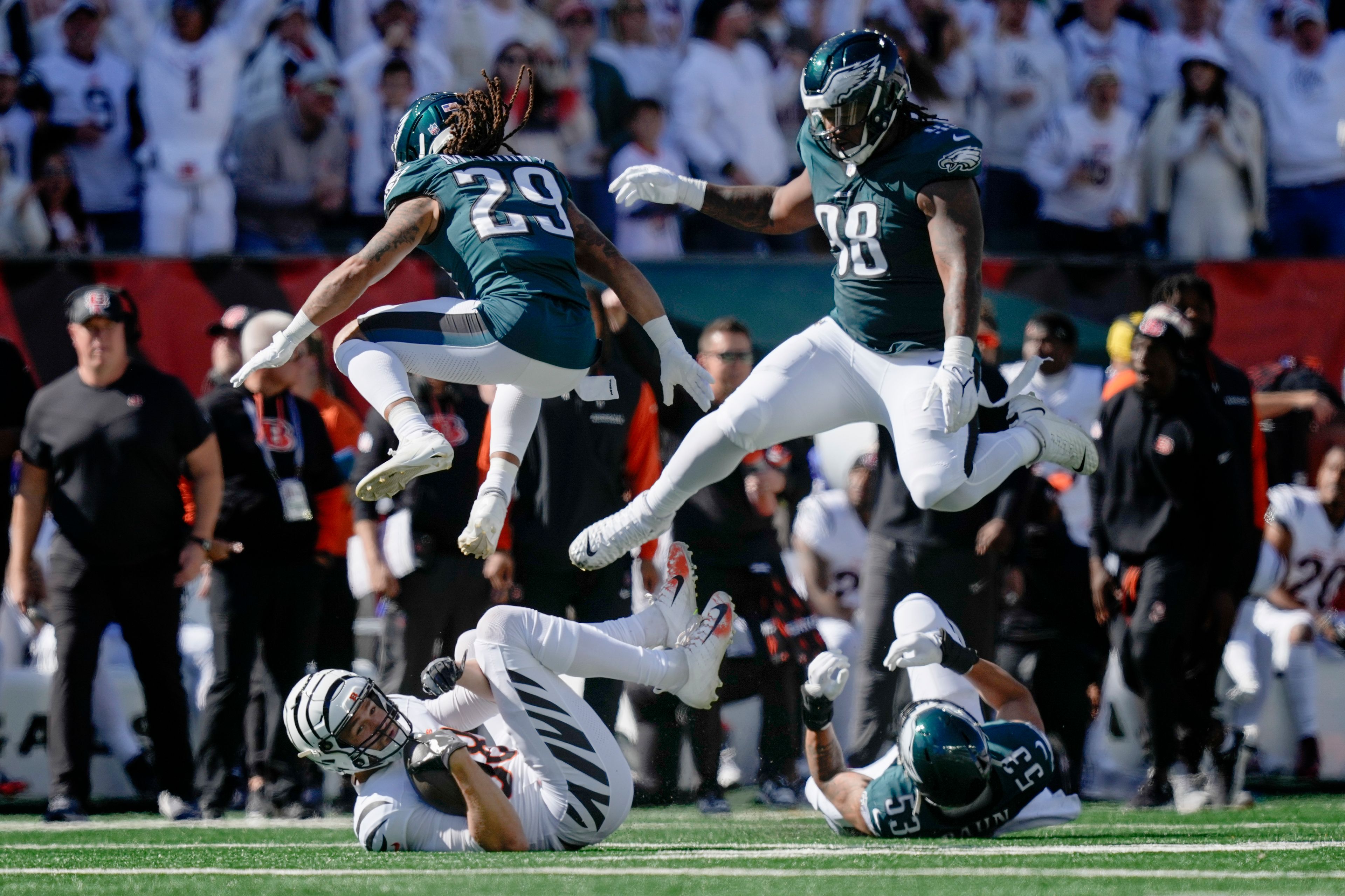 Philadelphia Eagles cornerback Avonte Maddox (29) and defensive tackle Jalen Carter (98) try to avoid contact with downed Cincinnati Bengals tight end Mike Gesicki, bottom left, and Eagles' Zack Baun (53) during the first half of an NFL football game, Sunday, Oct. 27, 2024 in Cincinnati. (AP Photo/Carolyn Kaster)