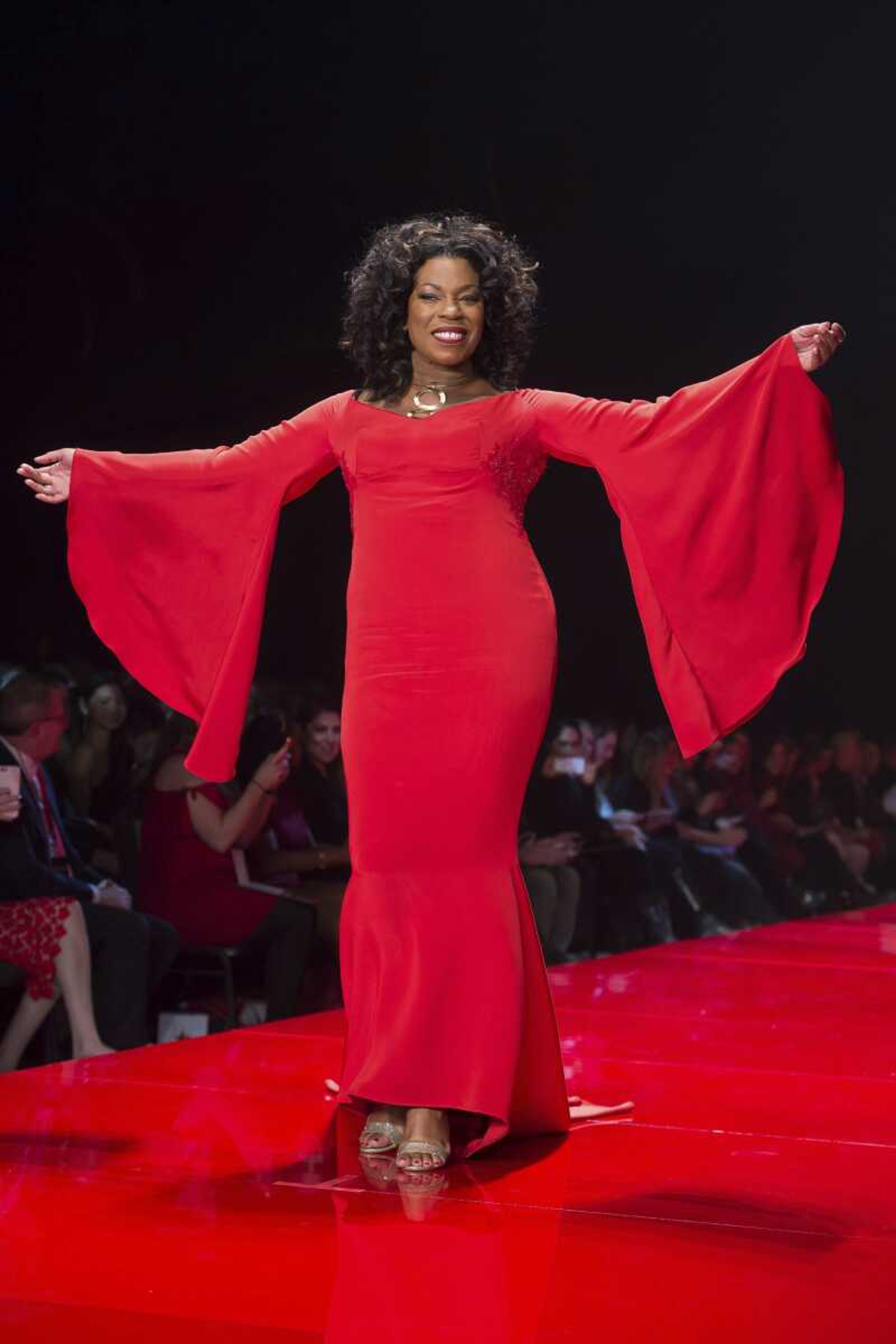 Actress Lorraine Toussaint wears a dress with wide sleeves as she walks the runway in the Red Dress Collection 2017 show during Fashion Week in New York.