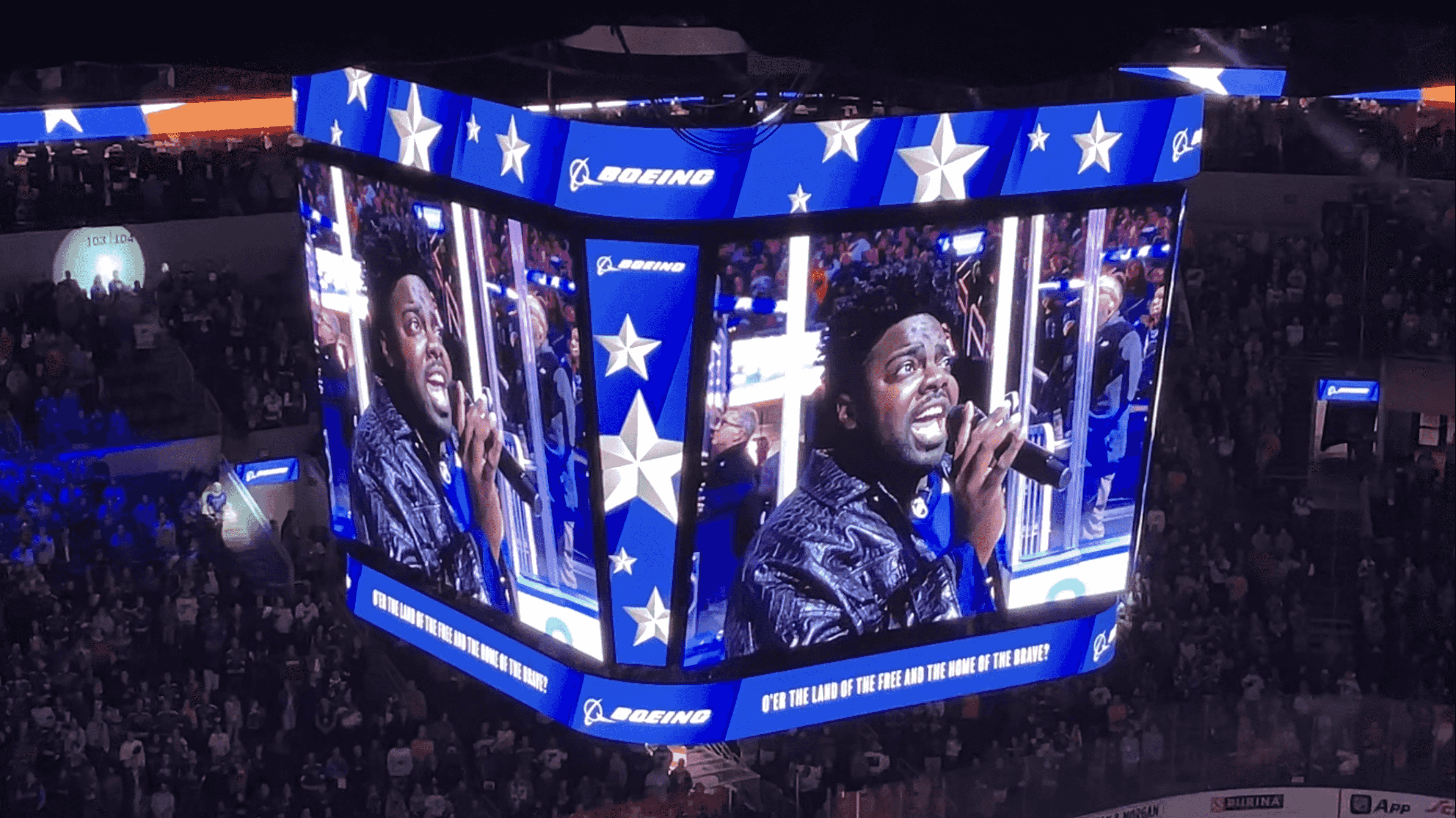 Notre Dame tennis coach Pershard Owens is seen on the Jumbotron as he sings the national anthem before the St. Louis Blues 2024-25 home opener against the Minnesota Wild on Tuesday, Oct. 15, in St. Louis. 