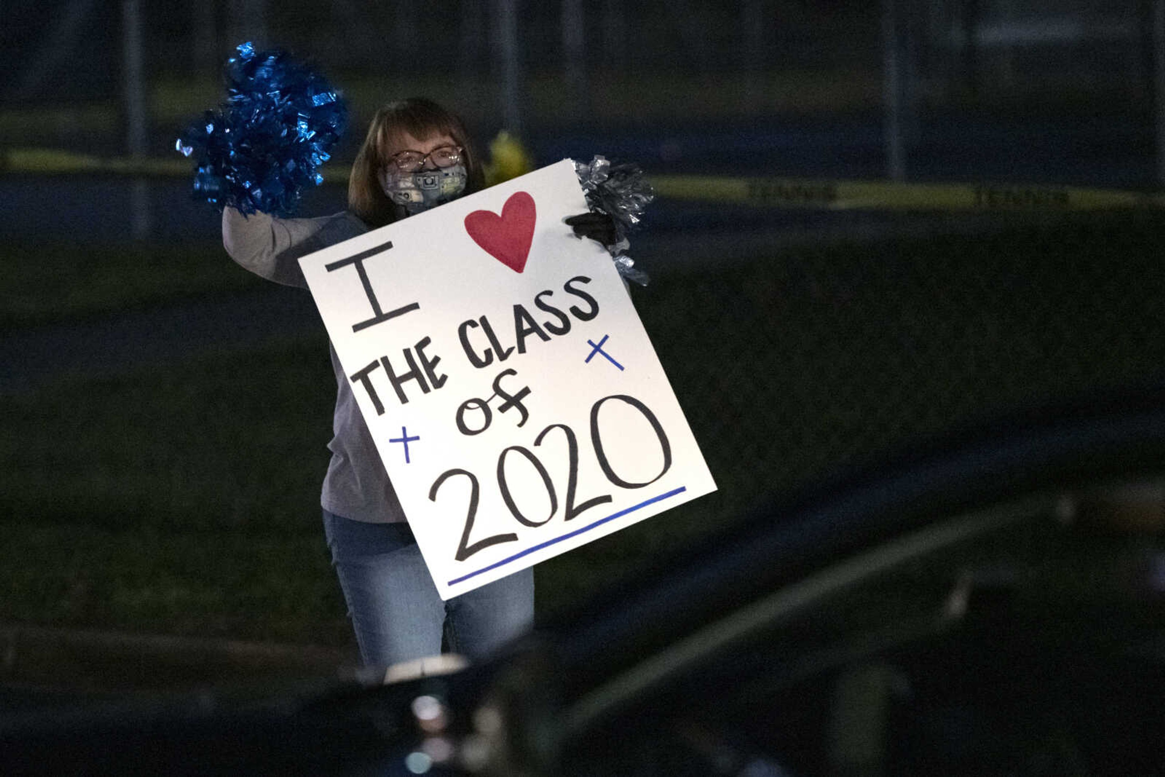 Shelly Powderly, director of the media center at Notre Dame Regional High School, waves during a "Friday night lights" senior drive-through event Friday, May 1, 2020, at the school in Cape Girardeau.