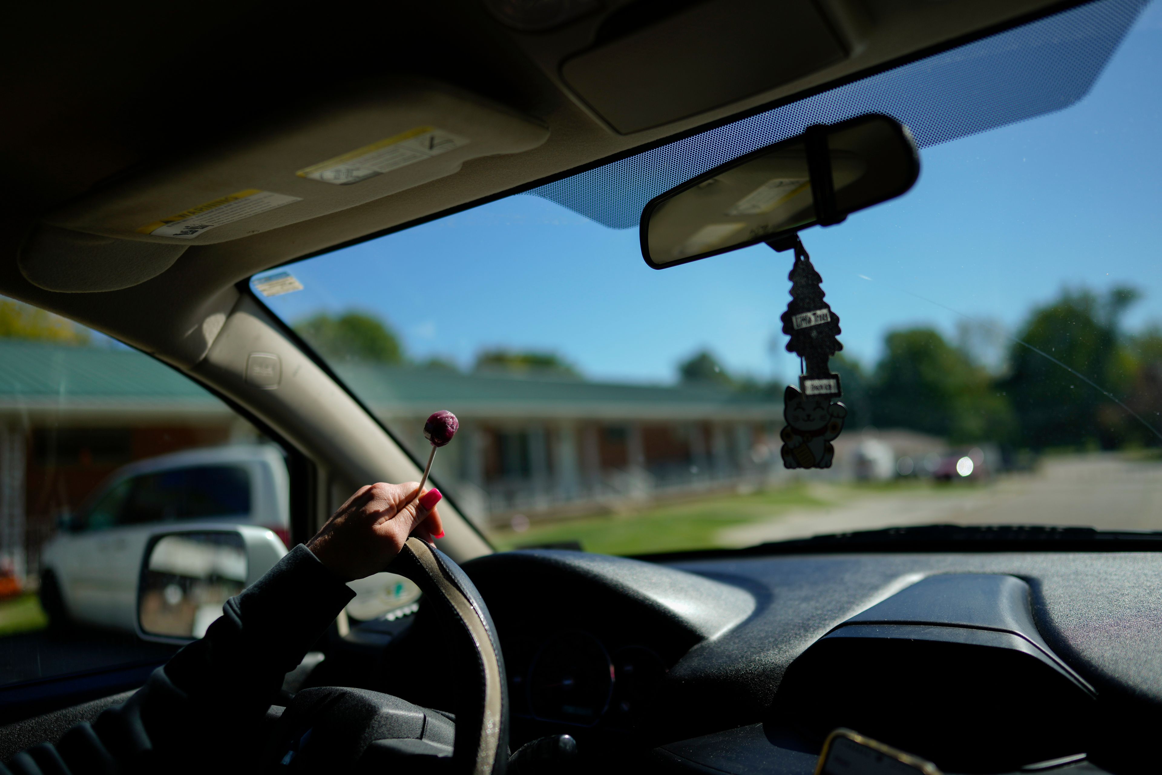 April Youst holds a grape lollipop as she drives in West Virginia on Wednesday, Oct. 9, 2024. (AP Photo/Carolyn Kaster)