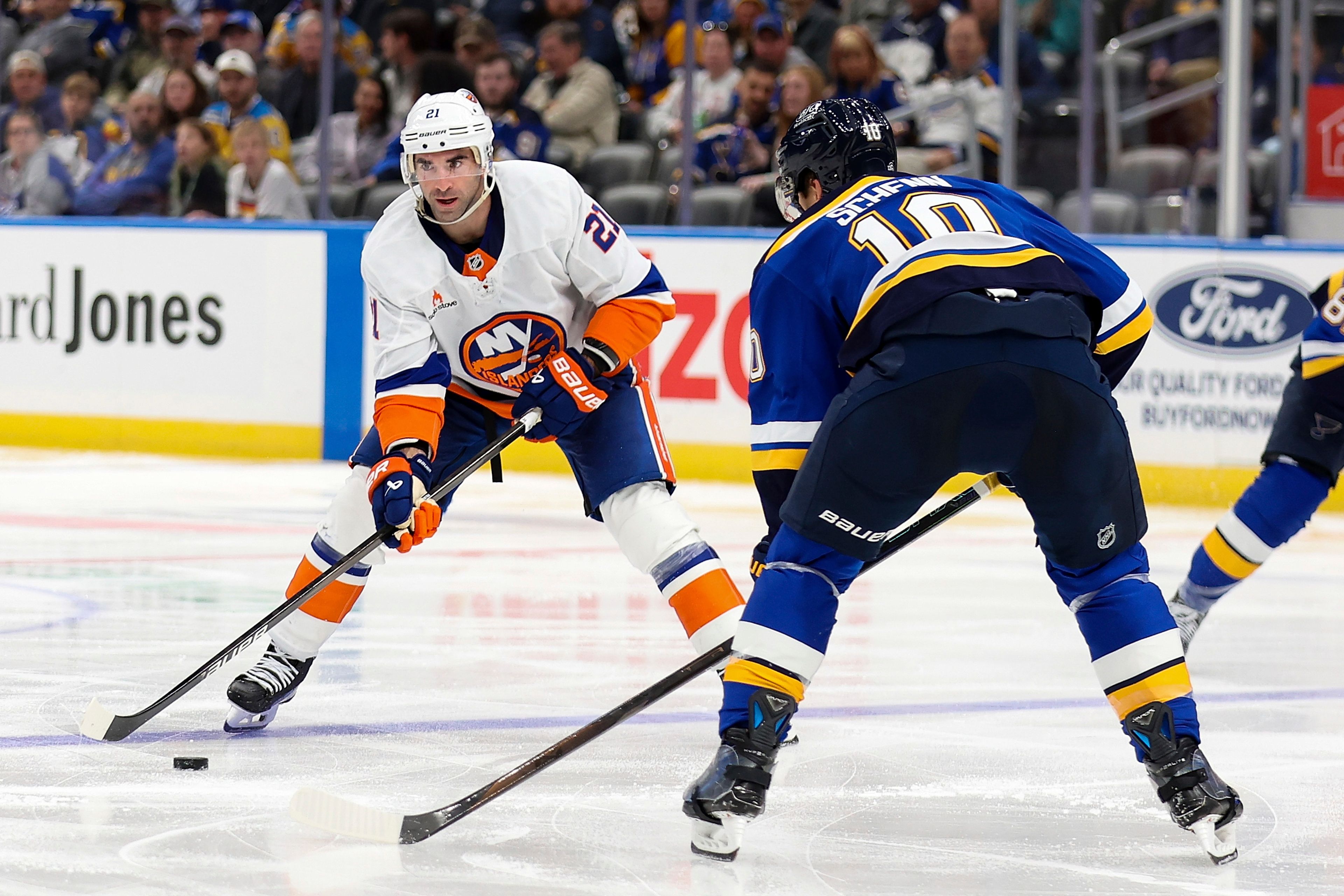 New York Islanders' Kyle Palmieri (21) controls the puck as St. Louis Blues' Brayden Schenn (10) defends during the third period of an NHL hockey game Thursday, Oct. 17, 2024, in St. Louis. (AP Photo/Scott Kane)