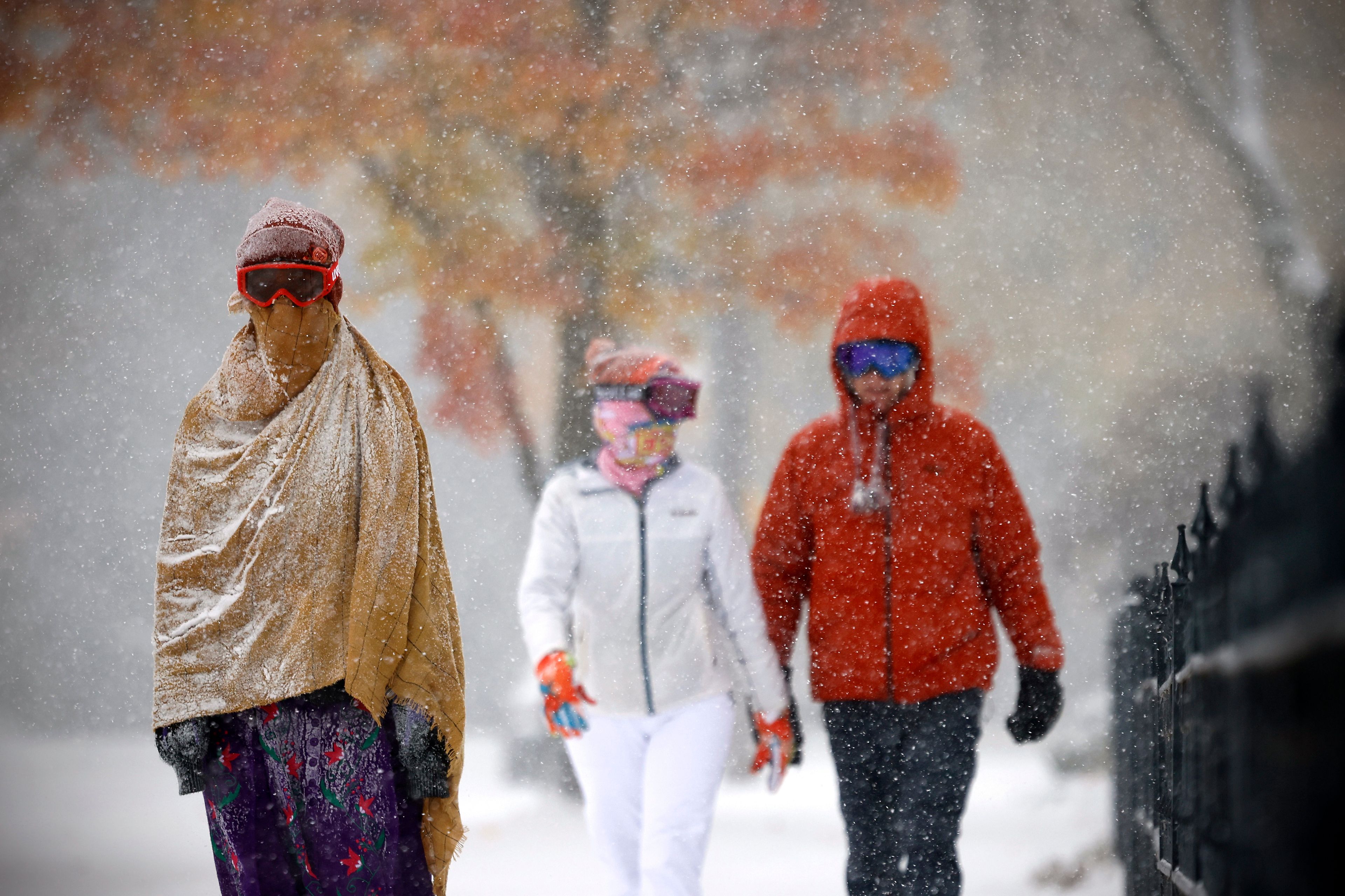 Emme Miller, 18, left, her mom, Jennifer, center, and dad, Darren, walk through the snow along Second Avenue in the Allendale neighboorhood in Kenosha, Wis., Thursday, Nov. 21, 2024. (Sean Krajacic/The Kenosha News via AP)