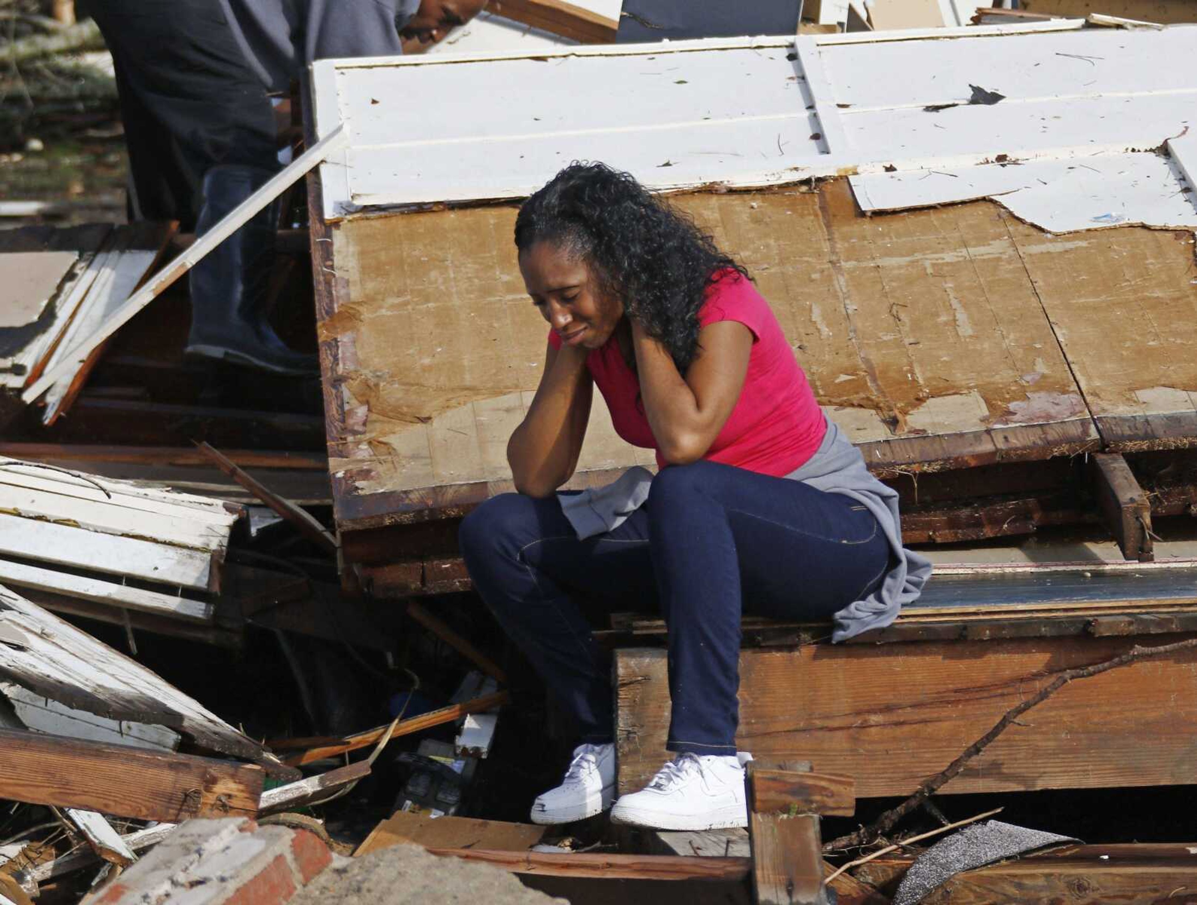 Shanise McMorris grieves on the slab of her Hattiesburg, Mississippi, home Saturday after an early tornado hit the city.