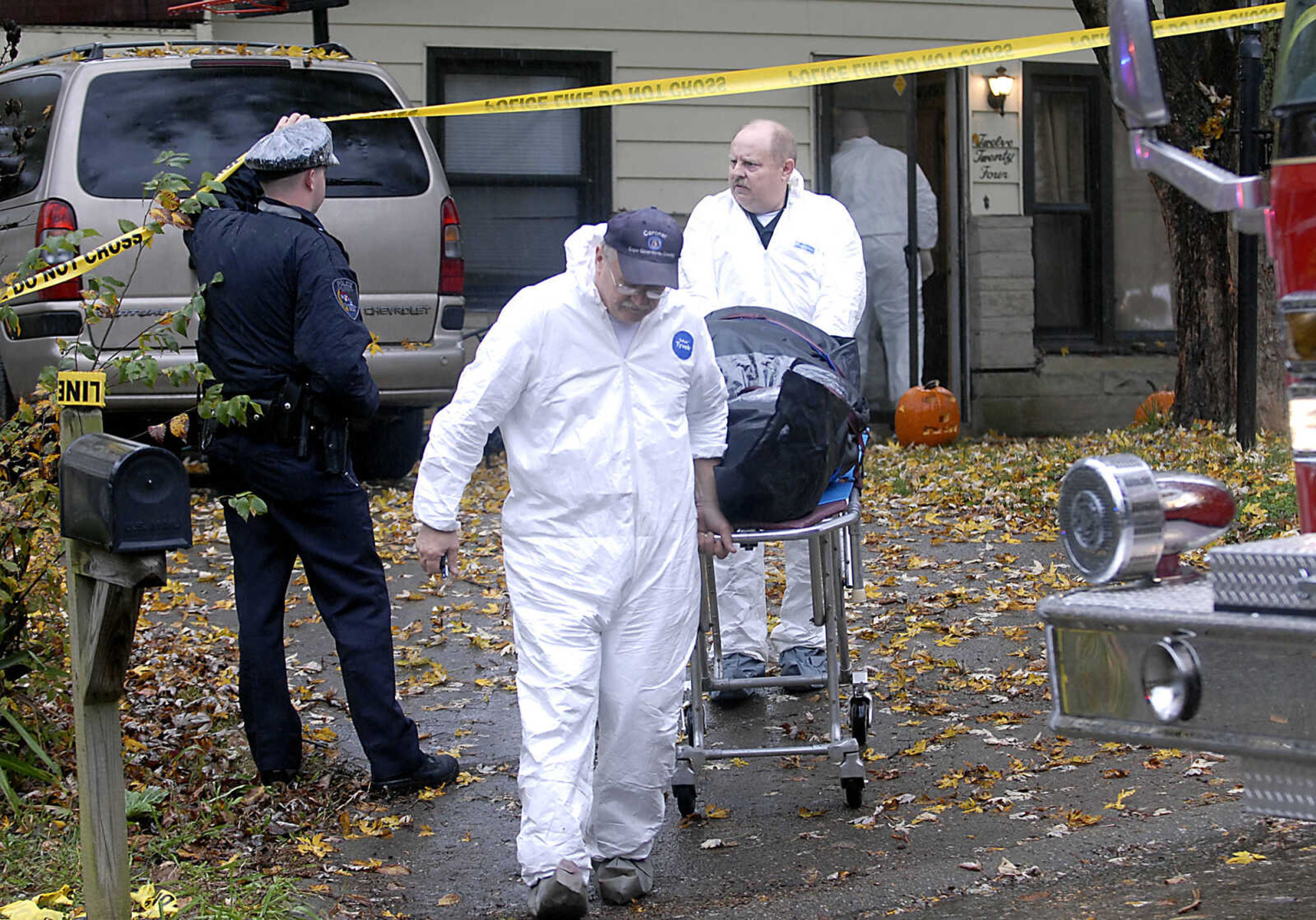 KIT DOYLE ~ kdoyle@semissourian.com
Cape Girardeau County Coroner John Clifton leads a victim's body from 1224 N. Missouri St. to his vehicle Tuesday morning, October 27, 2009, in Cape Girardeau.  There was a double homicide at the residence early Tuesday morning.