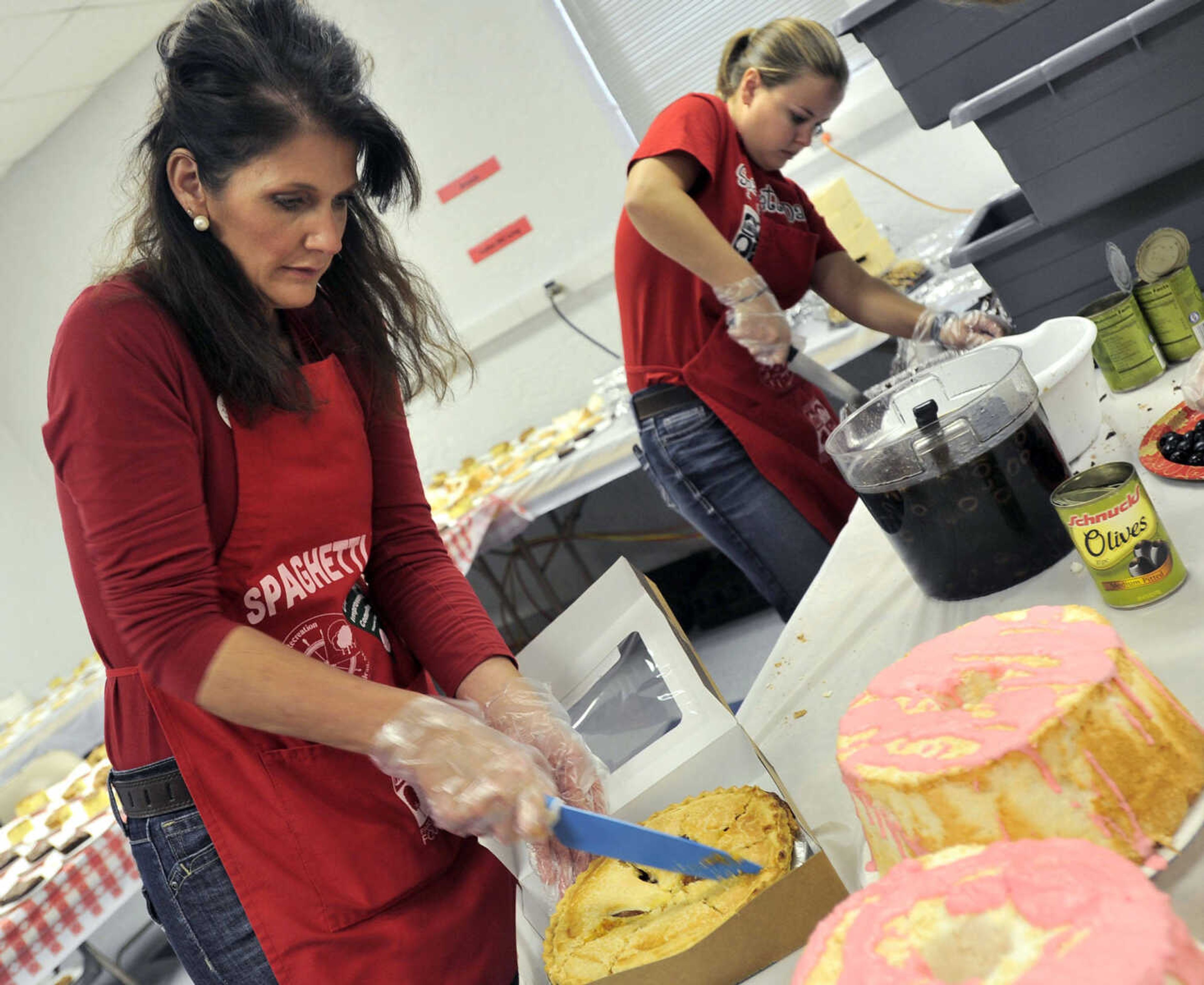 Stacy Welter, left, and Diane Boyer add garlic butter to bread for the Parks & Recreation Foundation Spaghetti Day Wednesday, Nov. 13, 2013 at the Arena Building.