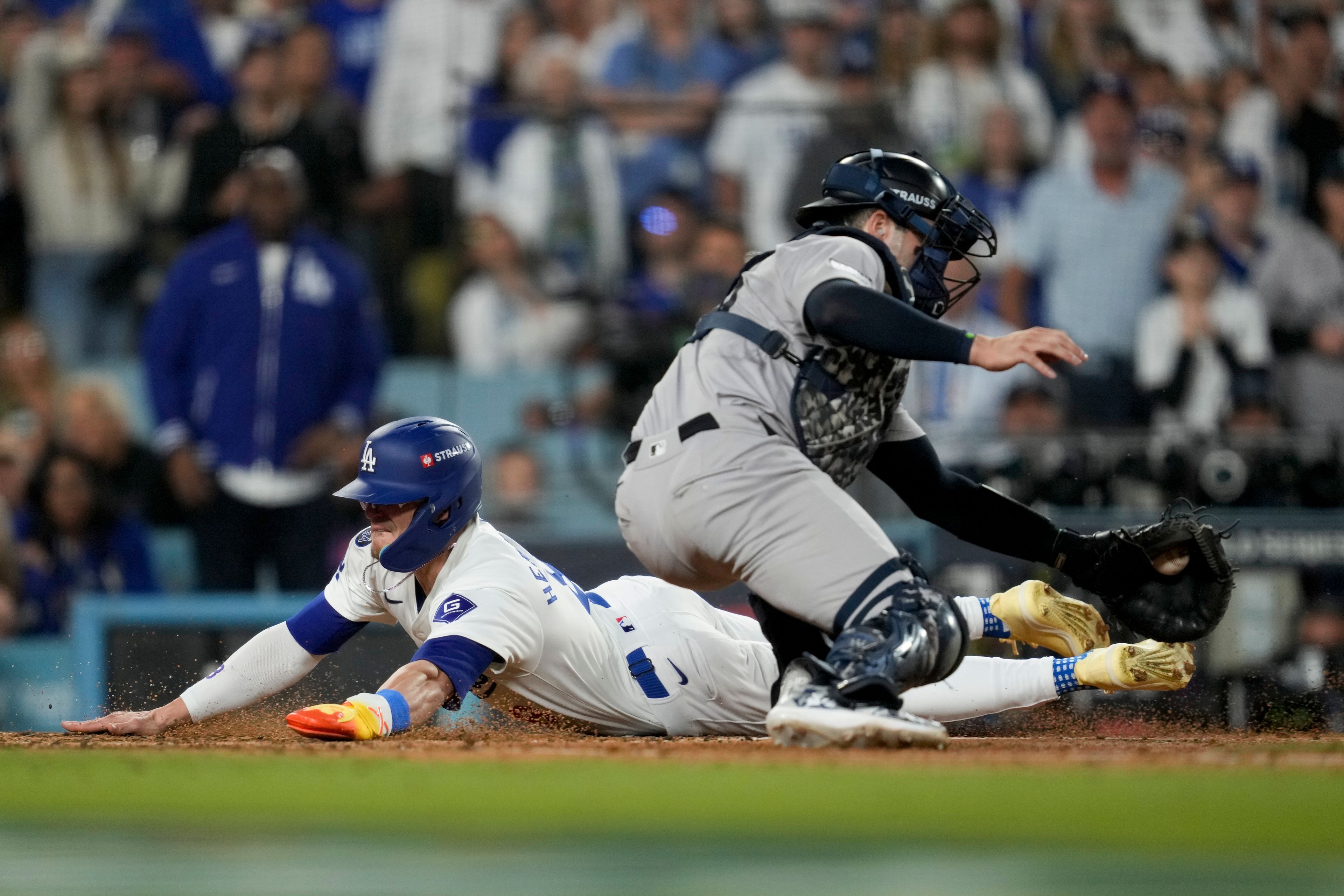 Los Angeles Dodgers' Kiké Hernández scores past New York Yankees catcher Austin Wells on a sacrifice fly by Will Smith during the fifth inning in Game 1 of the baseball World Series, Friday, Oct. 25, 2024, in Los Angeles. (AP Photo/Ashley Landis)