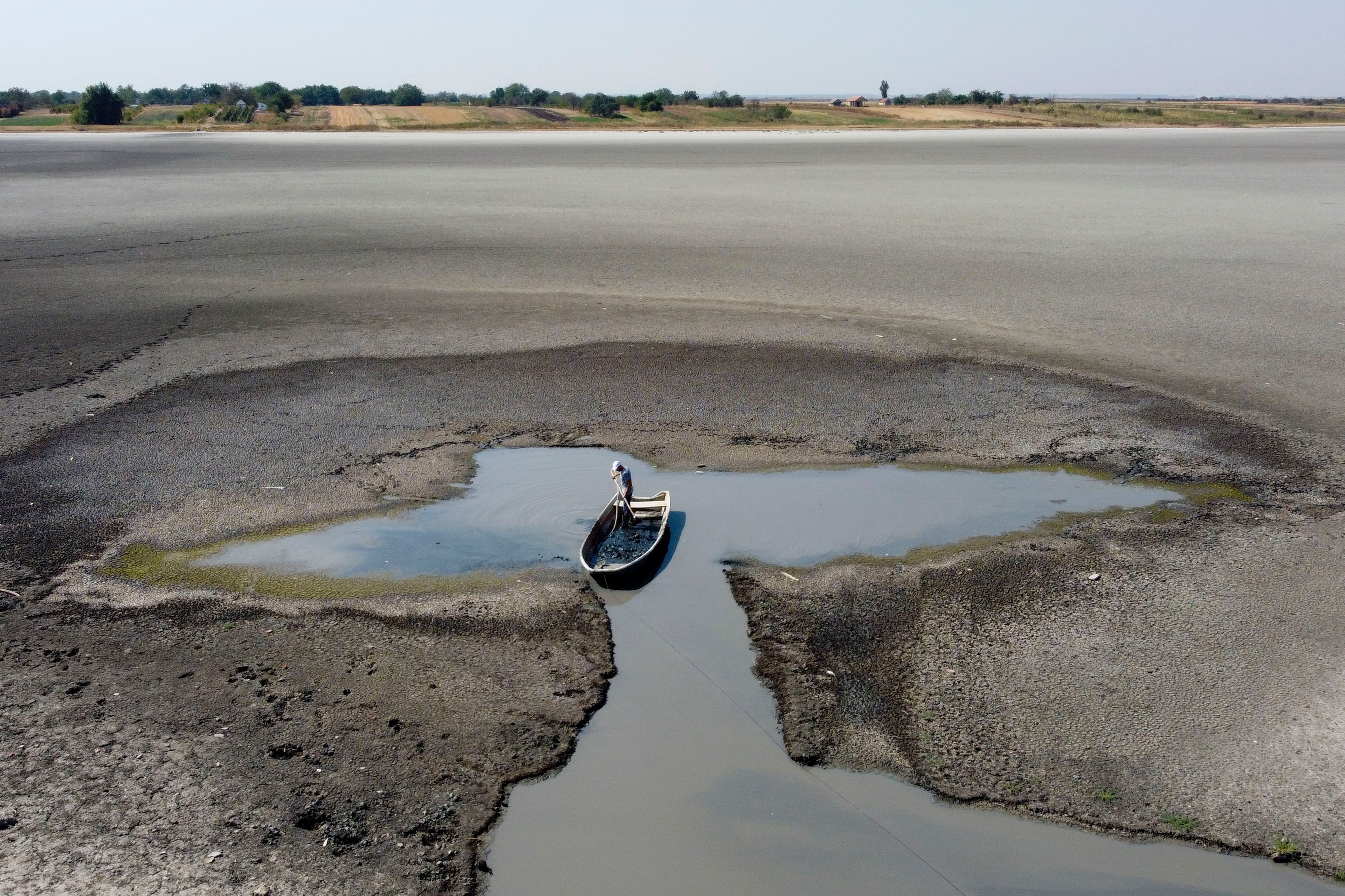 A man collects mud that is used in medical therapy at the dried out Rusanda salty lake, near Melenci, Serbia, Wednesday, Sept. 4, 2024. (AP Photo/Darko Vojinovic)