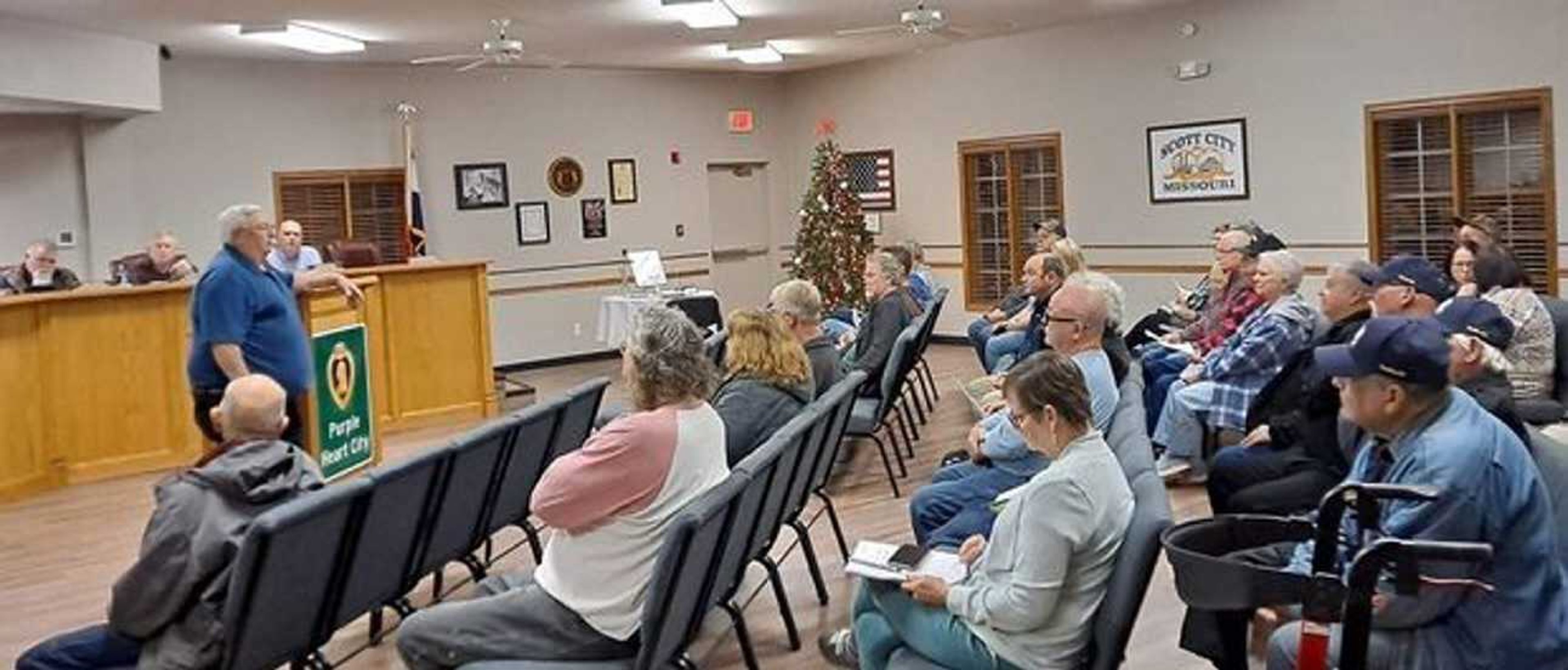 Mayor Norman Brant displays a Purple Heart City banner to attendees of the Dec. 5 meeting of Scott City Council. George Washington, whose profile adorns the medal, presented the first Purple Heart, then designated as a badge of merit, in 1782.