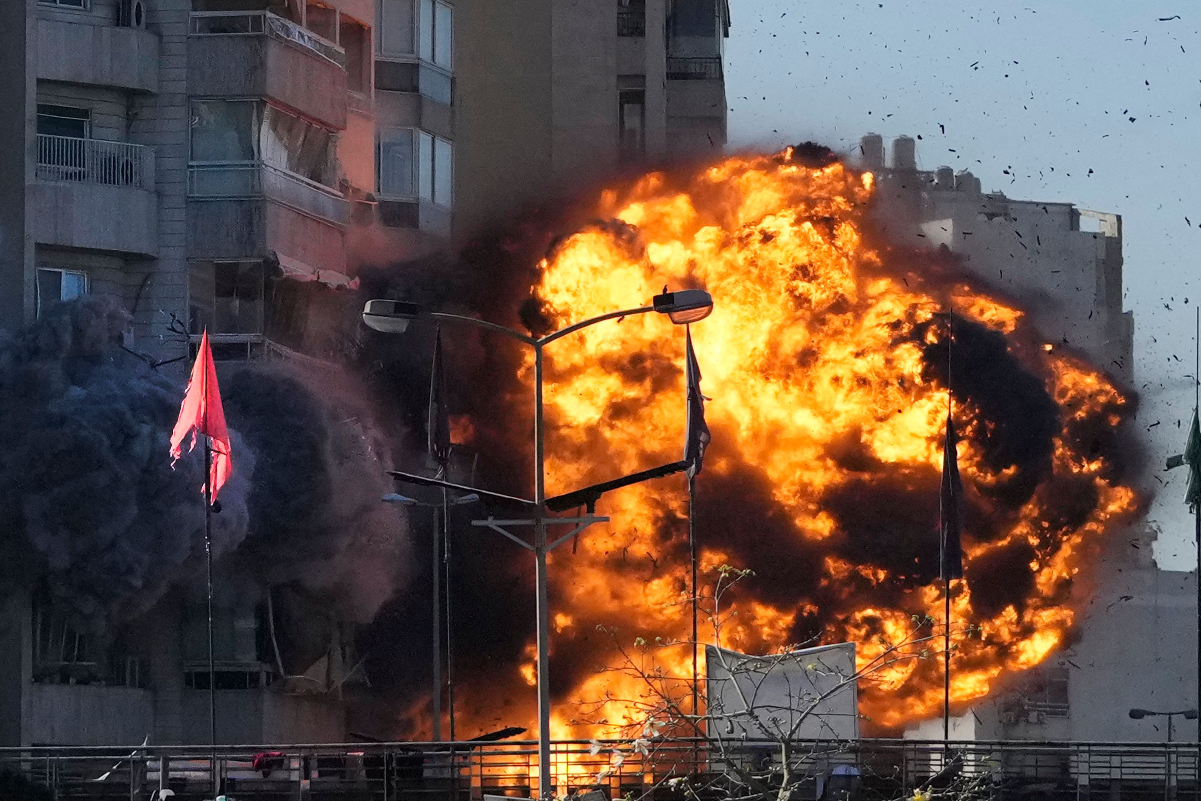 Smoke and flames erupt from a building hit in an Israeli airstrike in Tayouneh, Beirut, Lebanon, Friday, Nov. 15, 2024. (AP Photo/Hassan Ammar)