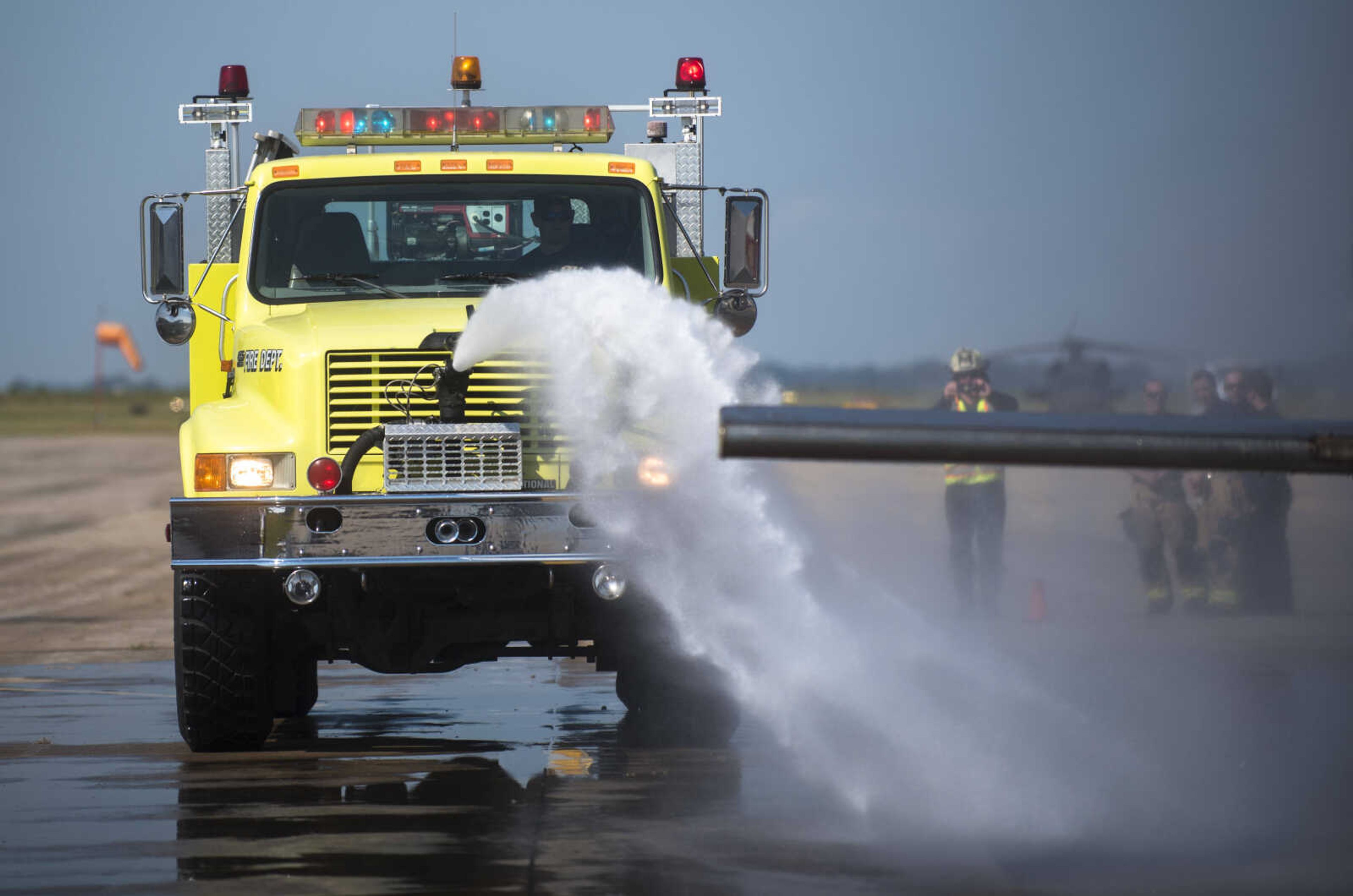 A firefighter guiding a firetruck hose puts out a ground fire and aircraft fire while area firefighters from Cape Girardeau, Gordonville and Scott City run airplane fire drills at the Cape Girardeau Regional Airport Friday morning, Sept. 15, 2017 in Cape Girardeau.