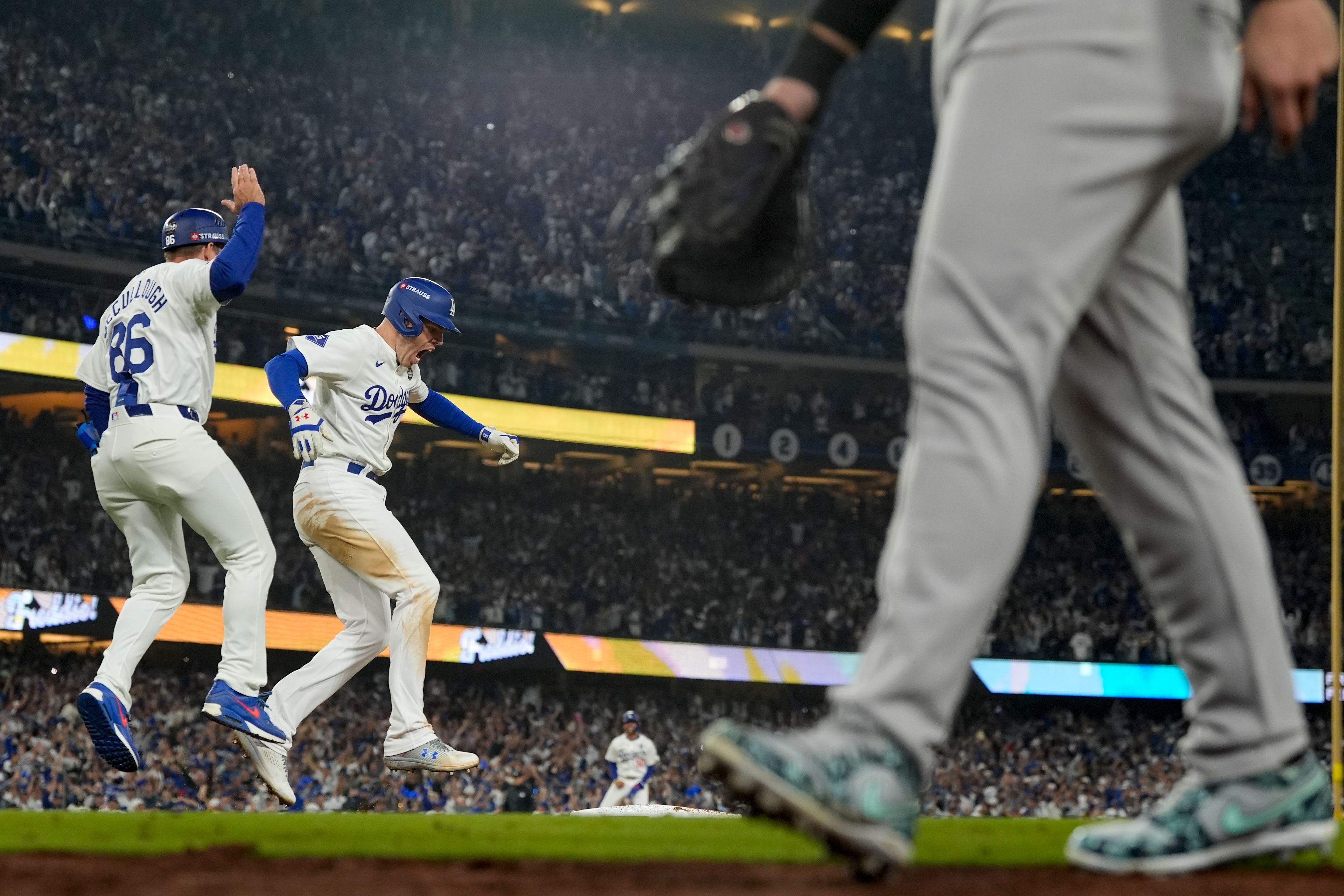 Los Angeles Dodgers' Freddie Freeman, middle, celebrates his walk-off grand slam home run against the New York Yankees during the 10th inning in Game 1 of the baseball World Series, Friday, Oct. 25, 2024, in Los Angeles. (AP Photo/Ashley Landis)