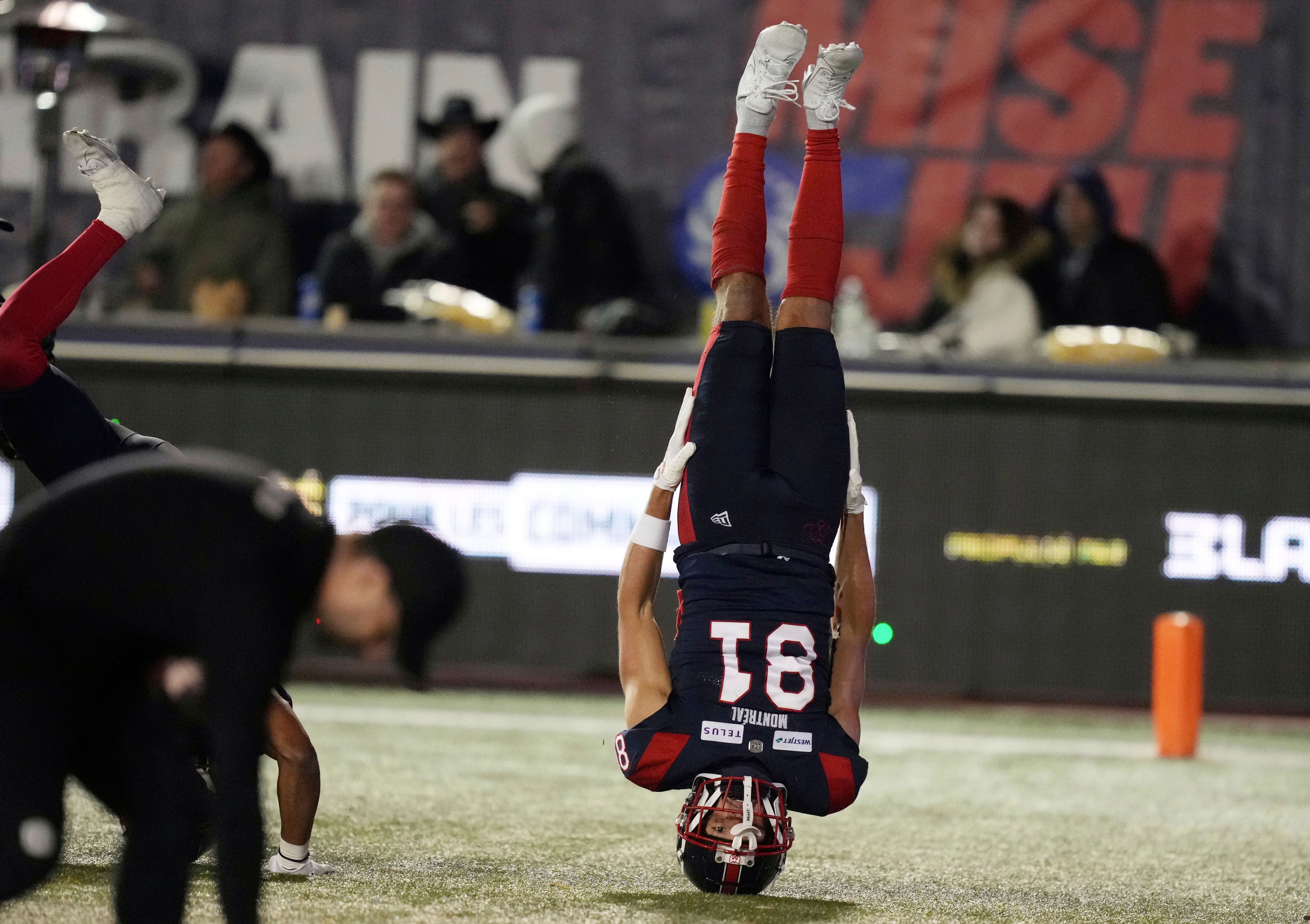 Montreal Alouettes wide receiver Austin Mack (81) stands on his head as he celebrates his touchdown against the Toronto Argonauts during the fourth quarter of a CFL eastern conference final football game, Saturday, Nov. 9, 2024 in Montreal. (Christinne Muschi/The Canadian Press via AP)