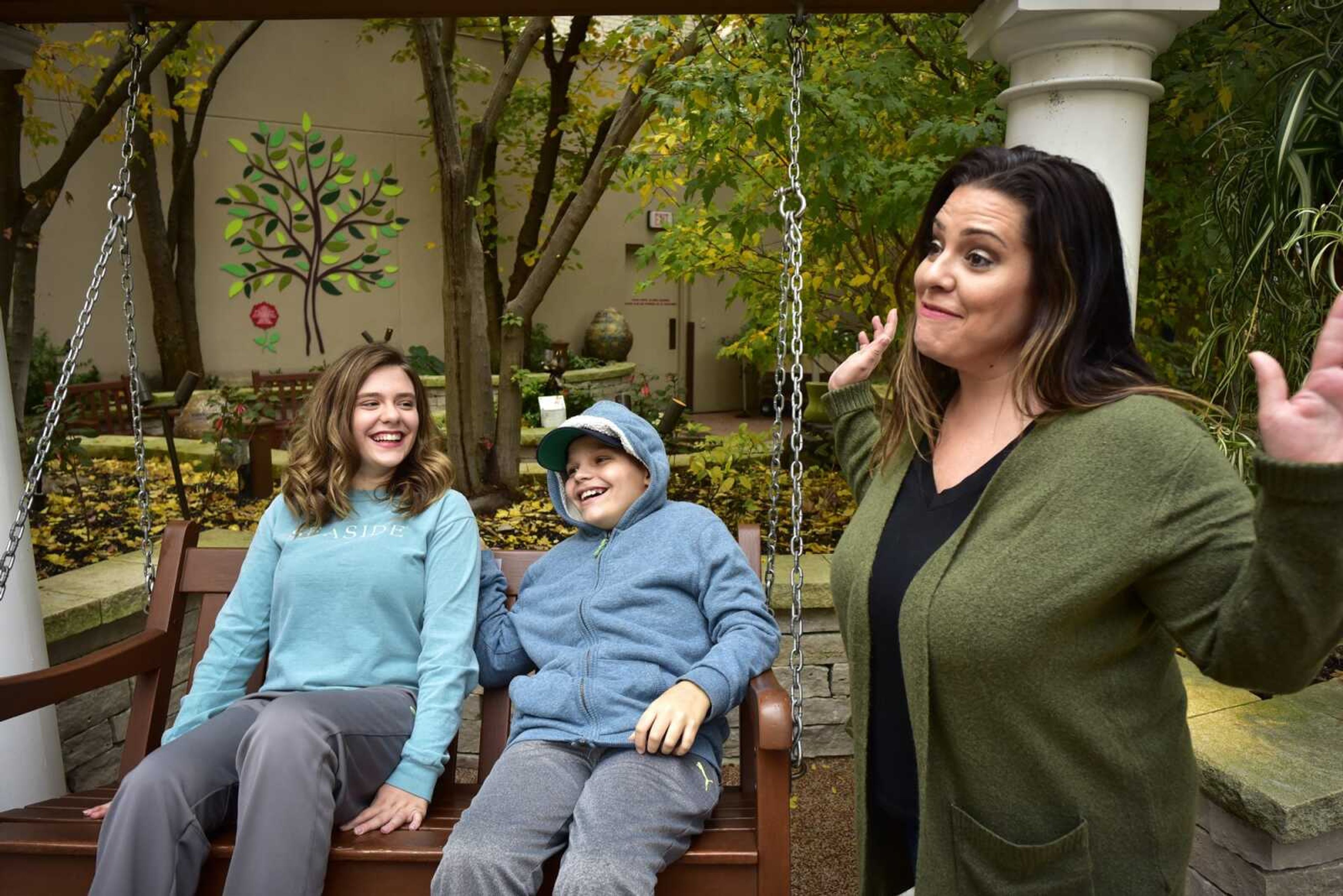 Cape Girardeau twins Allee and Matthew McKee sit near their mother, Wendy McKee, as they laugh at a joke made by their father, Jason McKee (not pictured) on Oct. 29 in the Olson Family Garden at St. Louis Children's Hospital.