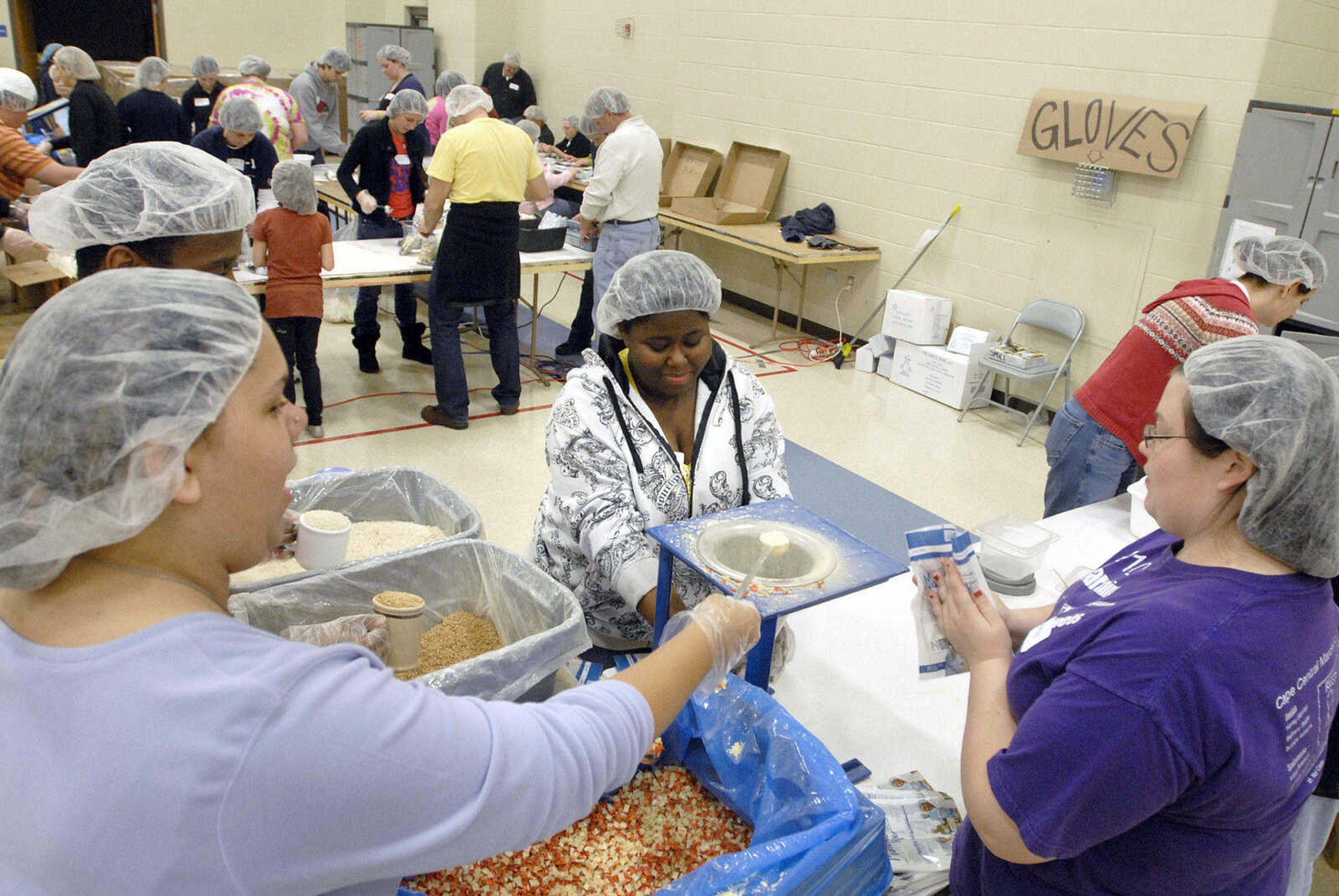 LAURA SIMON ~ lsimon@semissourian.com
Volunteers assemble the MannaPack Rice meals with chicken, veggies, soy and rice Friday night, Dec. 9, 2011 during the Feed My Starving Children Mobilepack event at Shawnee Park center in Cape Girardeau.