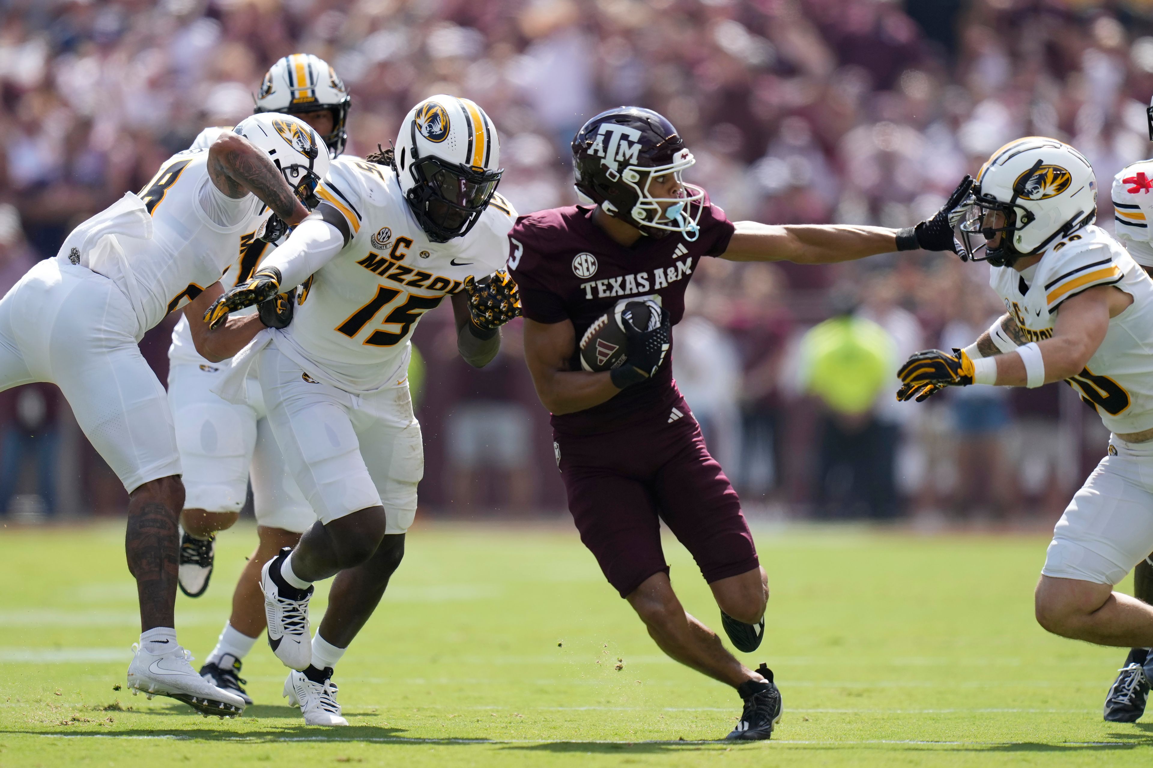 Texas A&M wide receiver Noah Thomas, center, runs between Missouri defensive end Johnny Walker Jr. (15) and linebacker Chuck Hicks (30) during the first half of an NCAA college football game Saturday, Oct. 5, 2024, in College Station, Texas. (AP Photo/Eric Gay)