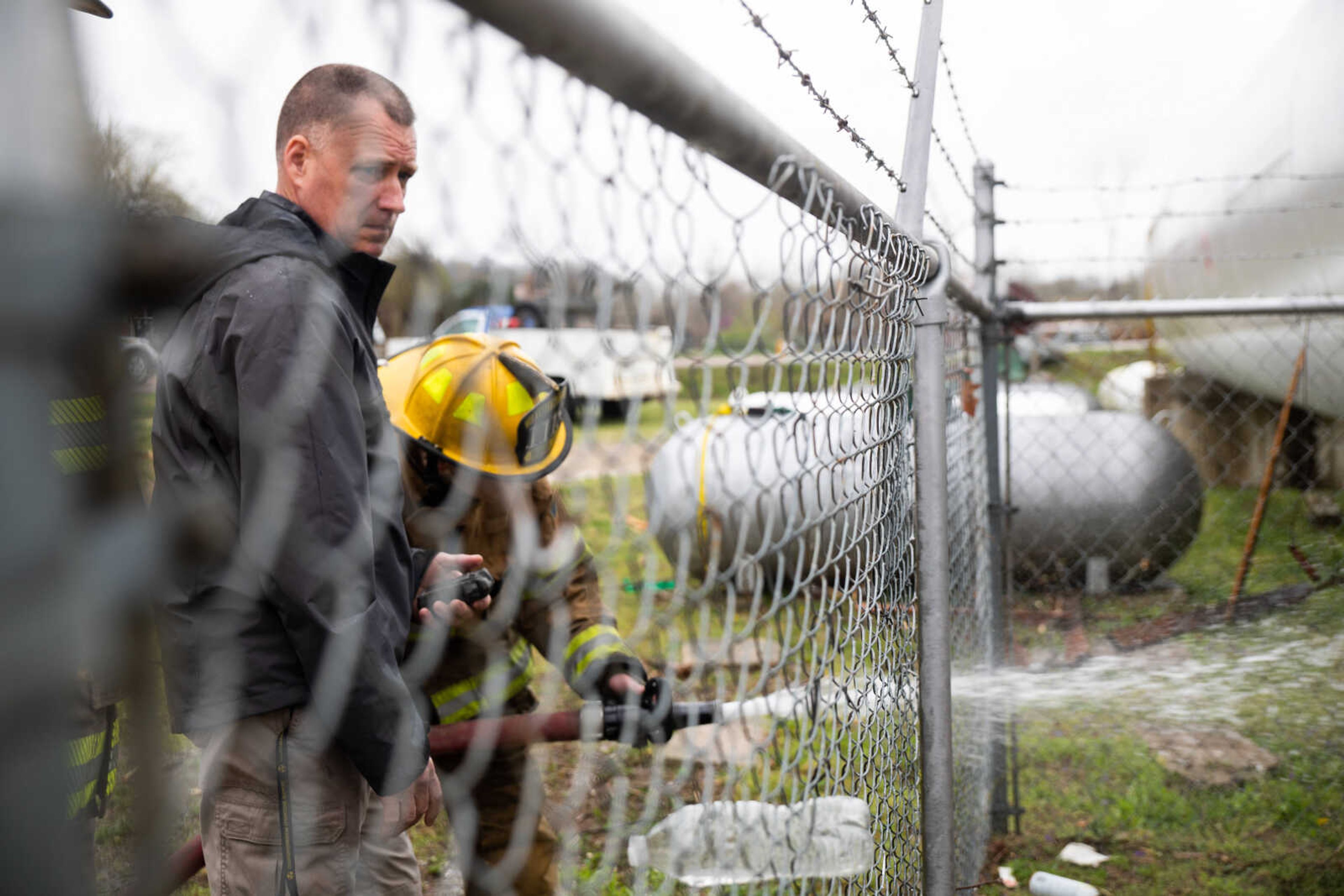 David Patten, an inspector for the Missouri Propane Safety Commission, watches as a firefighter uses a hose to thaw pipes frozen under a large propane tank, owned by M &amp; G Gas, that continued to leaked throughout the day.