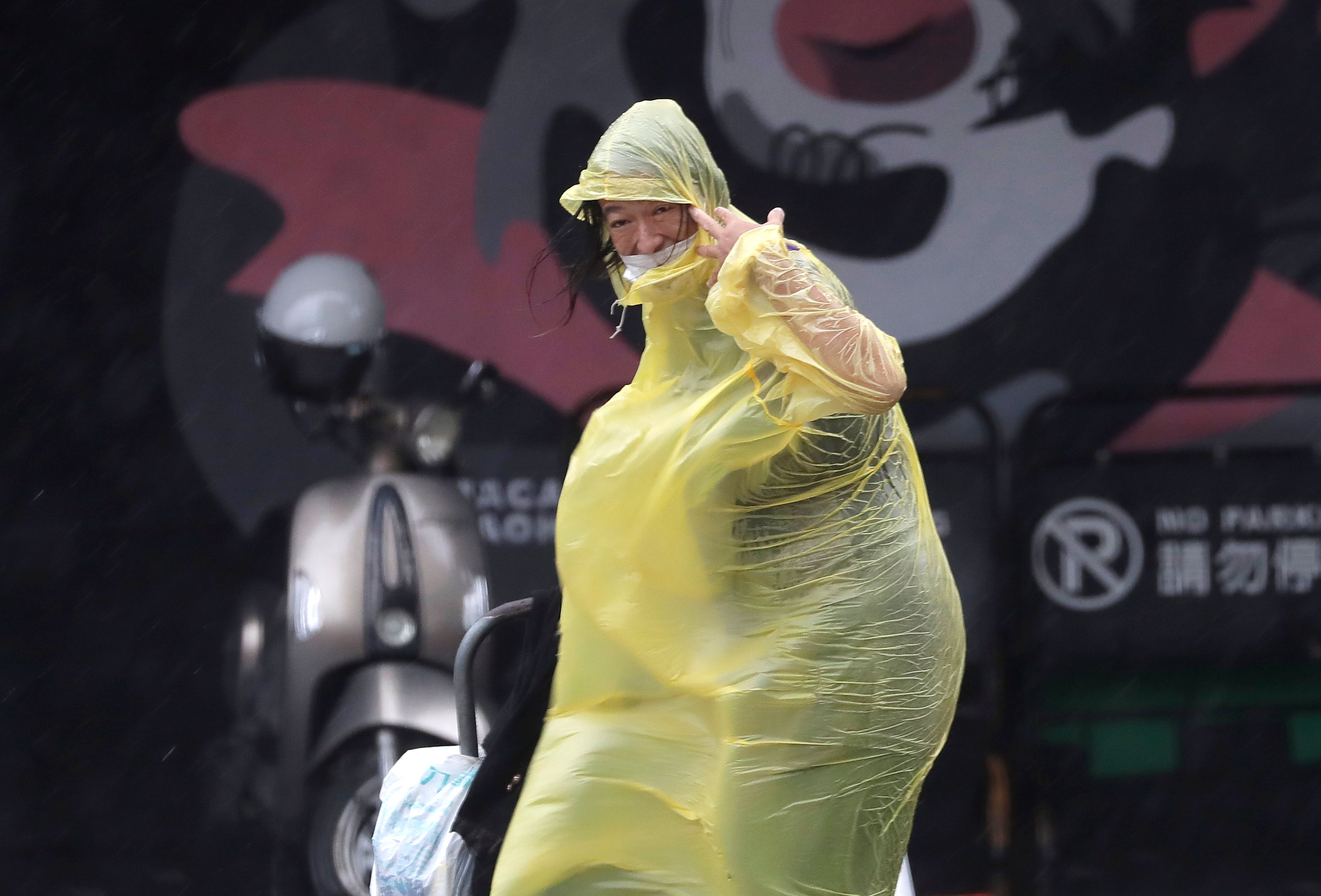 A woman struggles with winds generated by Typhoon Krathon in Kaohsiung, Southern Taiwan, Wednesday, Oct. 2, 2024. (AP Photo/Chiang Ying-ying)