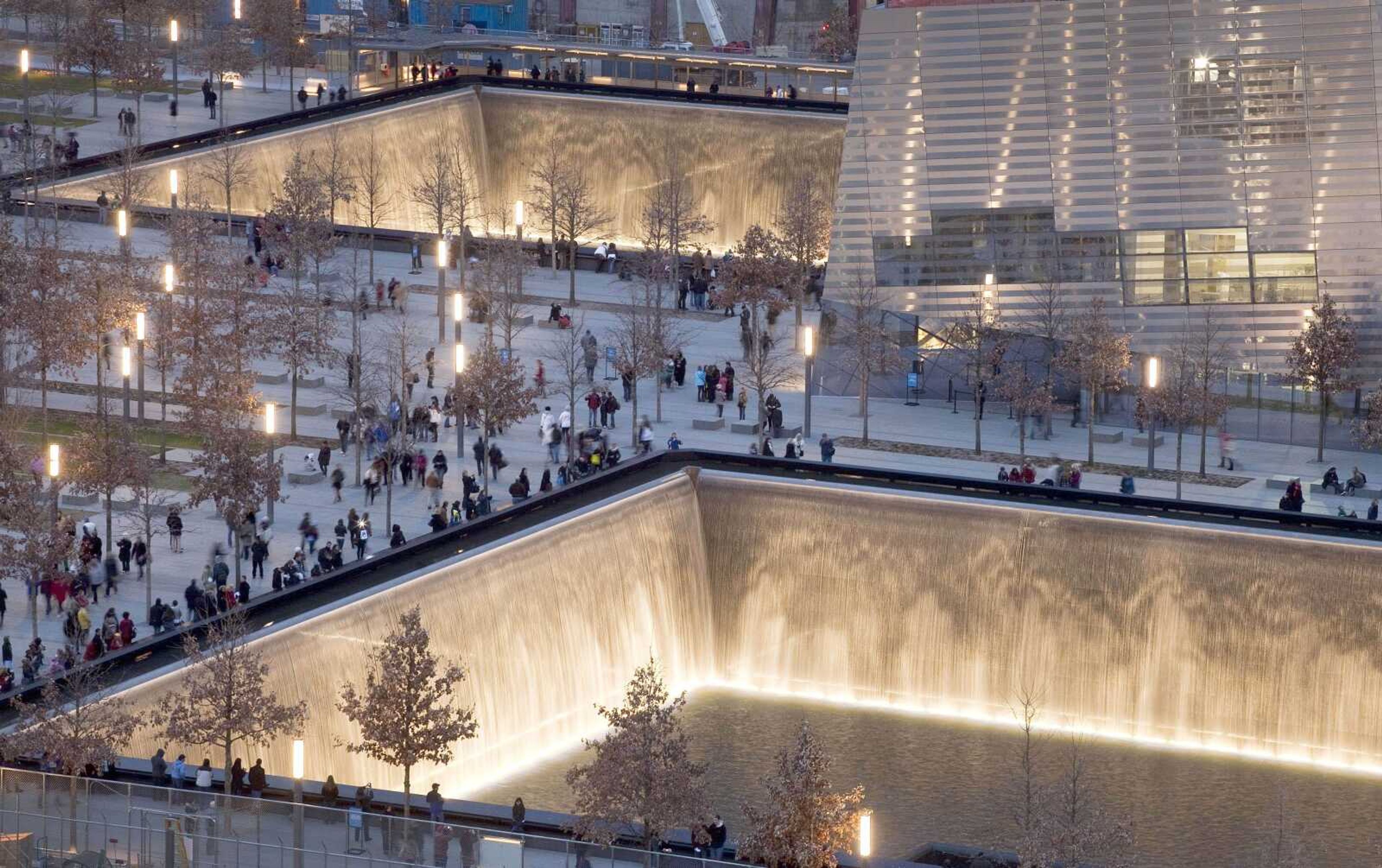 Visitors to the National Sept. 11 Memorial in New York walk around its twin pools Dec. 20. The foundation that runs the memorial estimates that once the roughly $700 million project is complete, it will cost $60 million a year to operate. (Associated Press file)