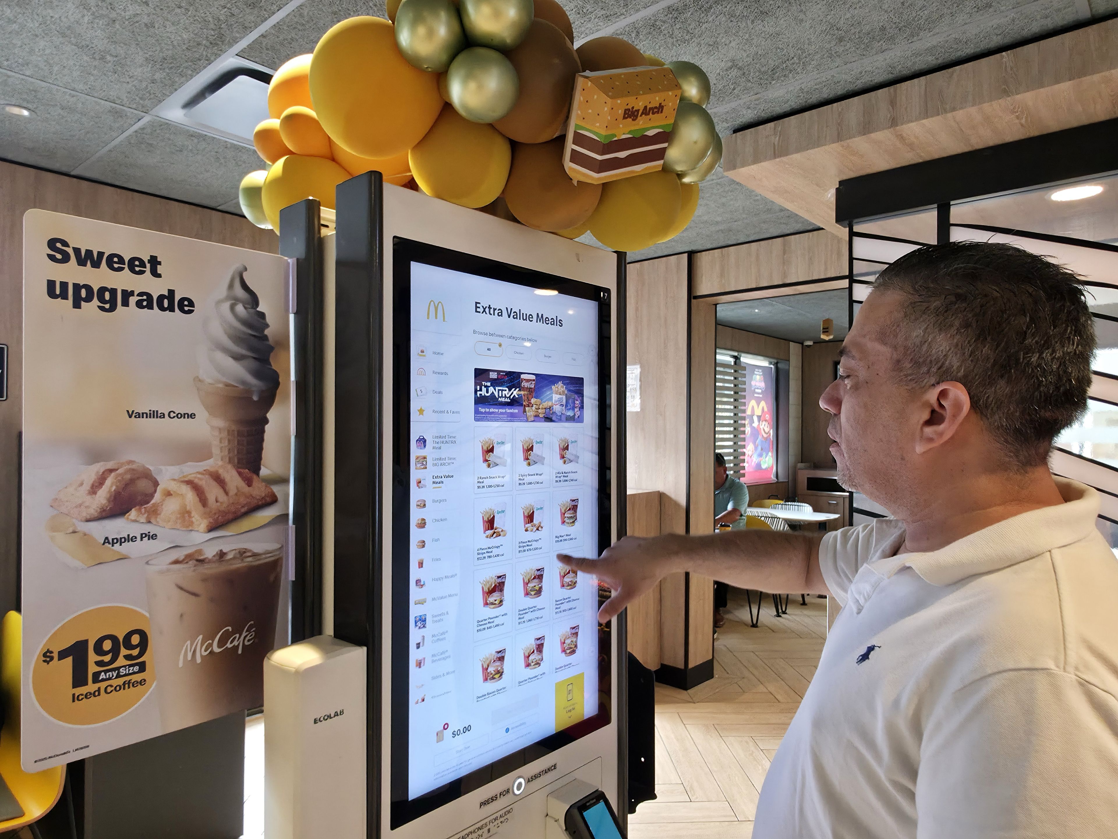 Carlos Paz picks a McValue menu selection at a McDonald's, Tuesday, March 31, 2026, in Los Angeles. (AP Photo/Damian Dovarganes)