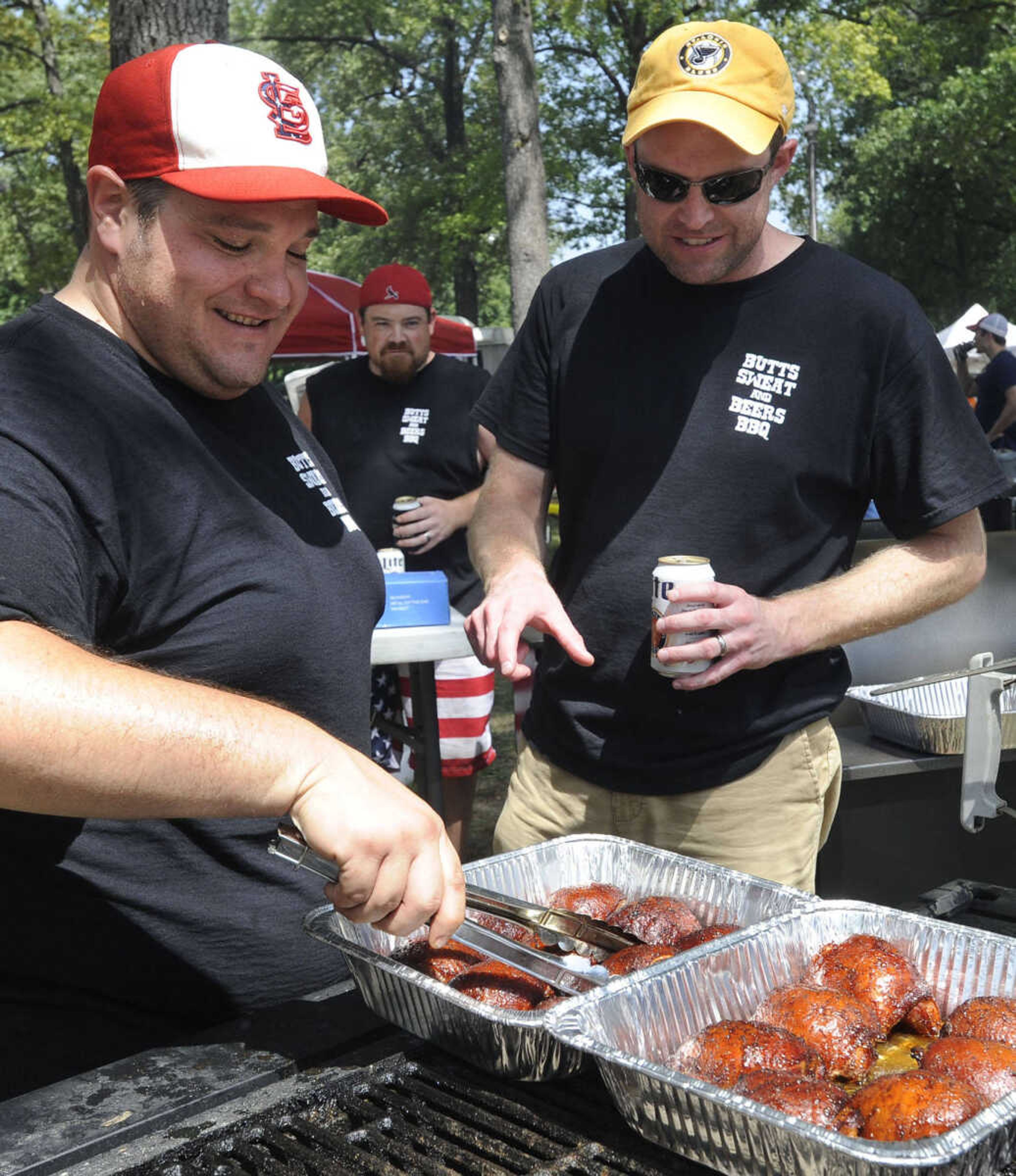 Gabriel Kinder, left, and Matt Godsey with Butts Sweat and Beers BBQ team prepare chicken for judging Saturday, Aug. 23, 2014 at the Cape BBQ Fest in Arena Park.