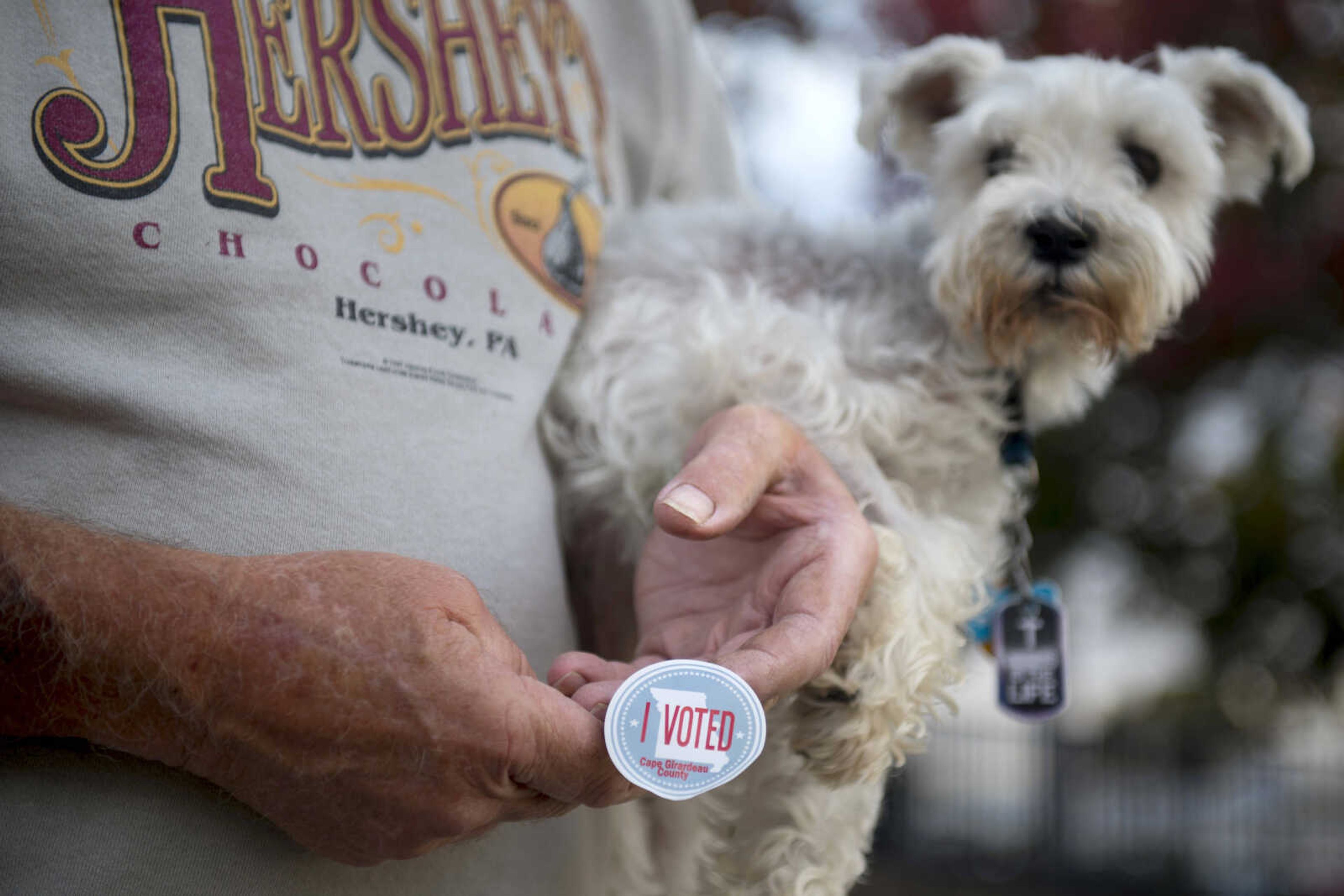 Larry Sikes, 70, carries his schnauzer, Twinkie, and an "I Voted" sticker out of the polling place after voting at at the A.C. Brase Arena Tuesday.
"I wanted to get the right senator in there," Sikes said. "[The sticker] is to make sure everybody knows I voted; I did my duty."