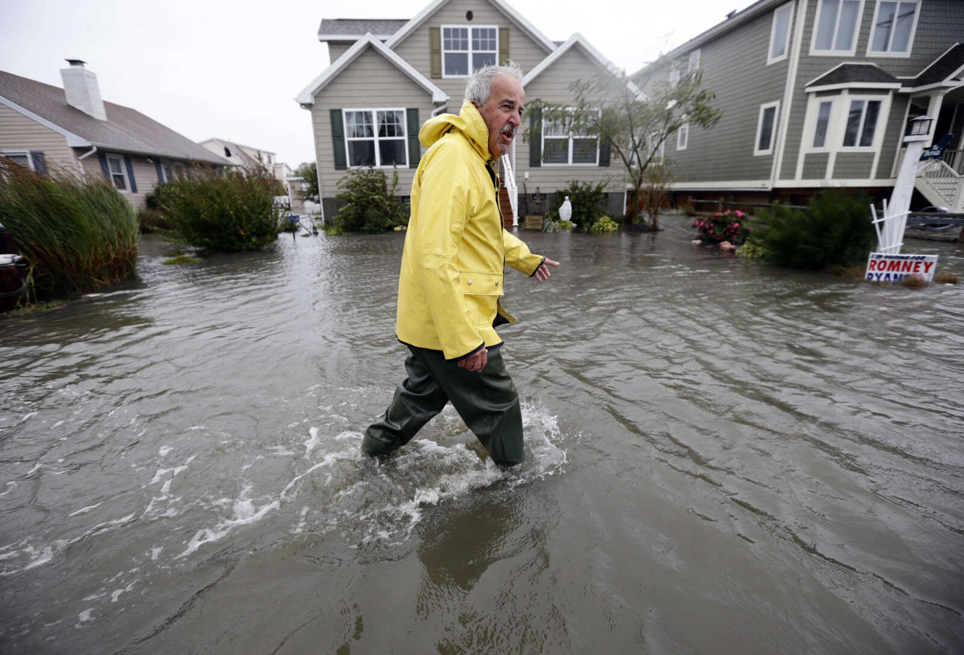 Richard Thomas walks through the flood waters in front of his home after assisting neighbors as Hurricane Sandy bears down on the East Coast, Monday, Oct. 29, 2012, in Fenwick Island, Del. Forecasters warned that the New York City region could face the worst of Hurricane Sandy as it bore down on the U.S. East Coast's largest cities Monday, forcing the shutdown of financial markets and mass transit, sending coastal residents fleeing and threatening high winds, rain and a wall of water up to 11 feet (3.35 meters) tall. It could endanger up to 50 million people for days.  (AP Photo/Alex Brandon)