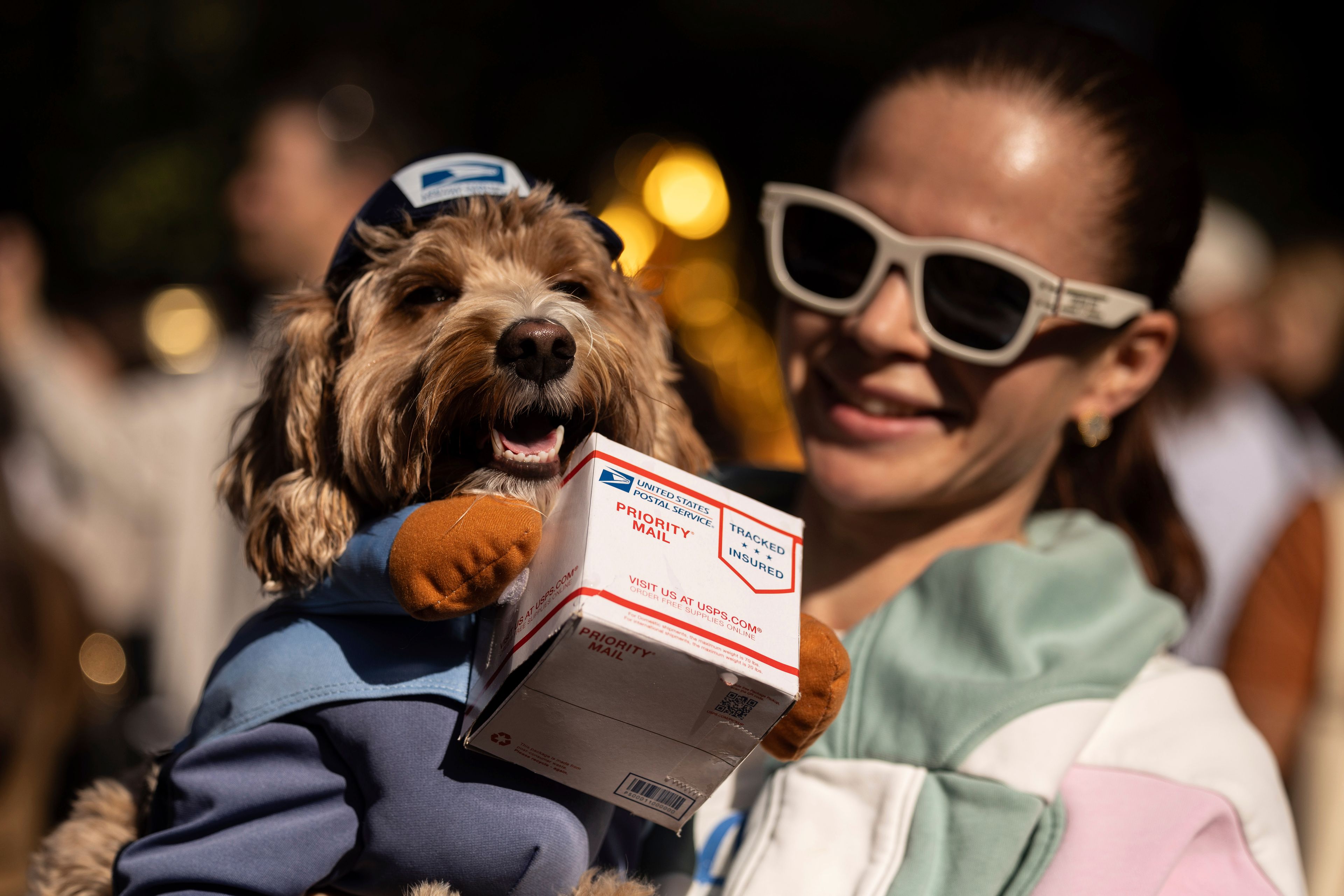 A person poses for photos with their dogs in costume during the 34th annual Tompkins Square Halloween Dog Parade, Saturday, Oct. 19, 2024, in New York. (AP Photo/Yuki Iwamura)