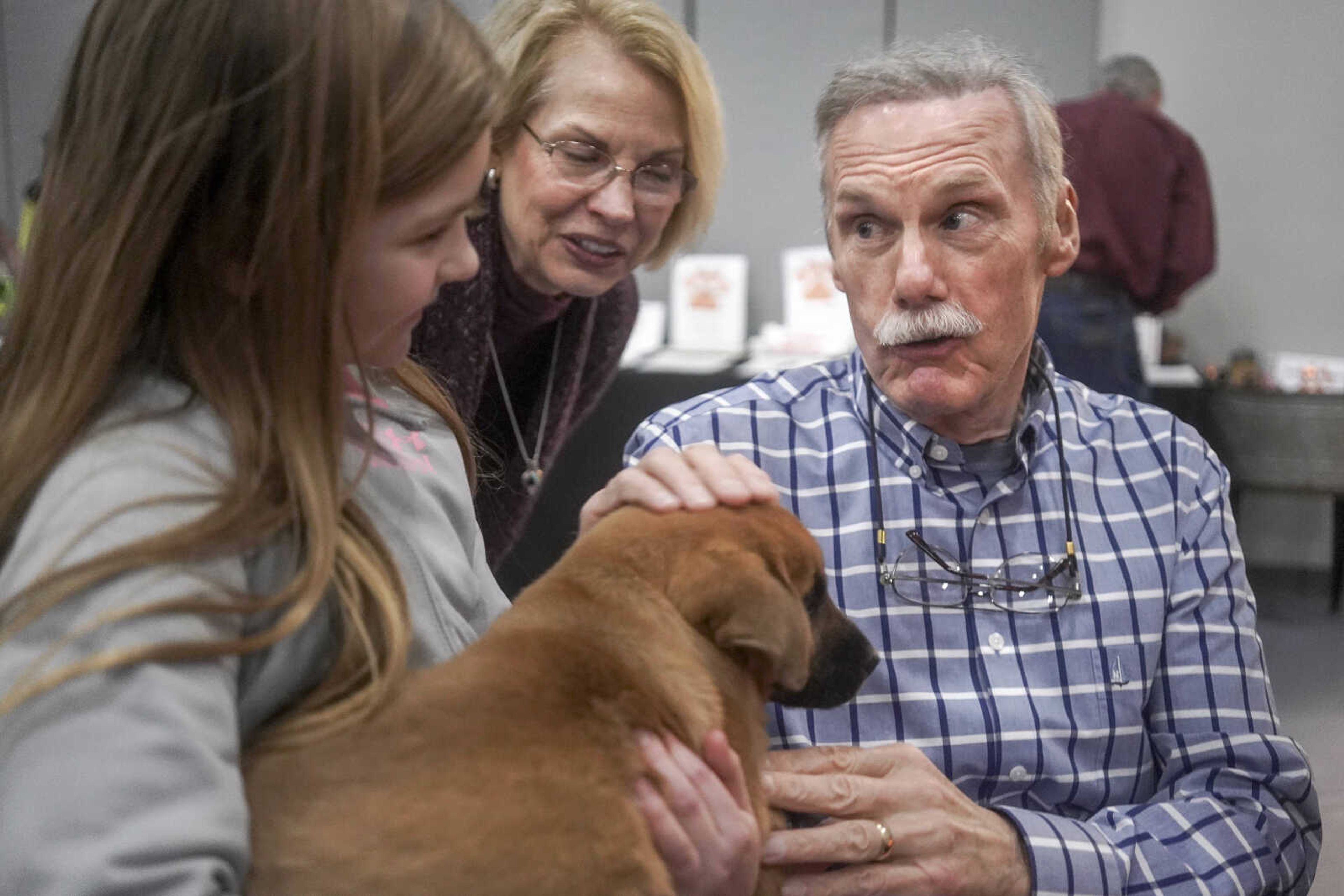 Walt Schroeder, right, pets a puppy held by Kaylee Blechle, left, during the Humane Society of Southeast Missouri Power of Pawsitivity fundraiser Saturday, Feb. 29, 2020, at the Jackson Civic Center in Jackson. 
Also pictured is Walt's wife, Cathy.