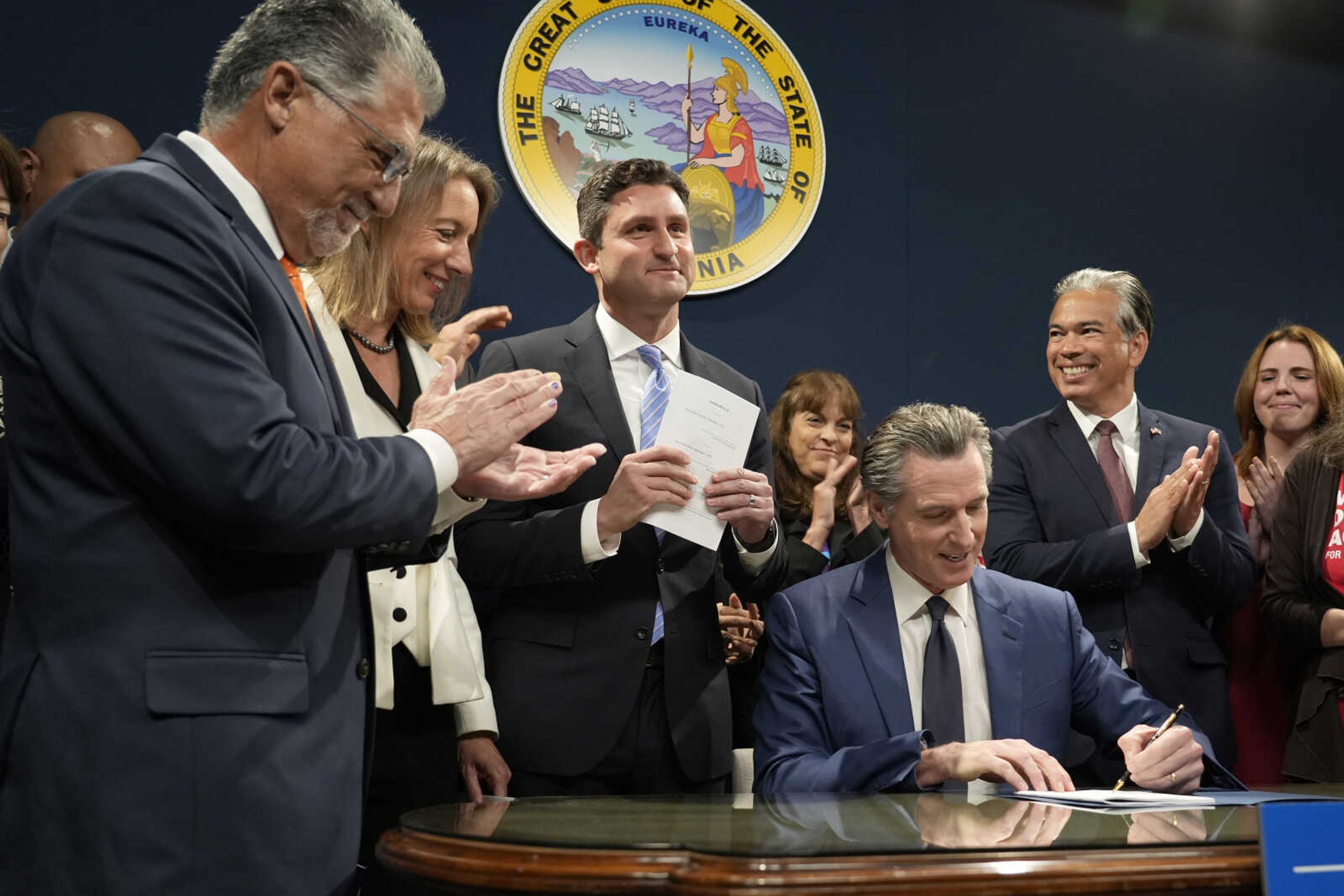 California Gov. Gavin Newsom signs a bill by state Sen. Anthony Portantino, D-Burbank, left, during a news conference in Sacramento, Calif., Tuesday, Sept.26, 2023. Newsom also signed a measure by state Sen. Catherine Blakespear, D-Encinitas, second from left, and a bill by Assemblymember Jesse Gabriel, D-Los Angeles County, third from left. Second from right is California Attorney General Rob Bonta. (AP Photo/Rich Pedroncelli)