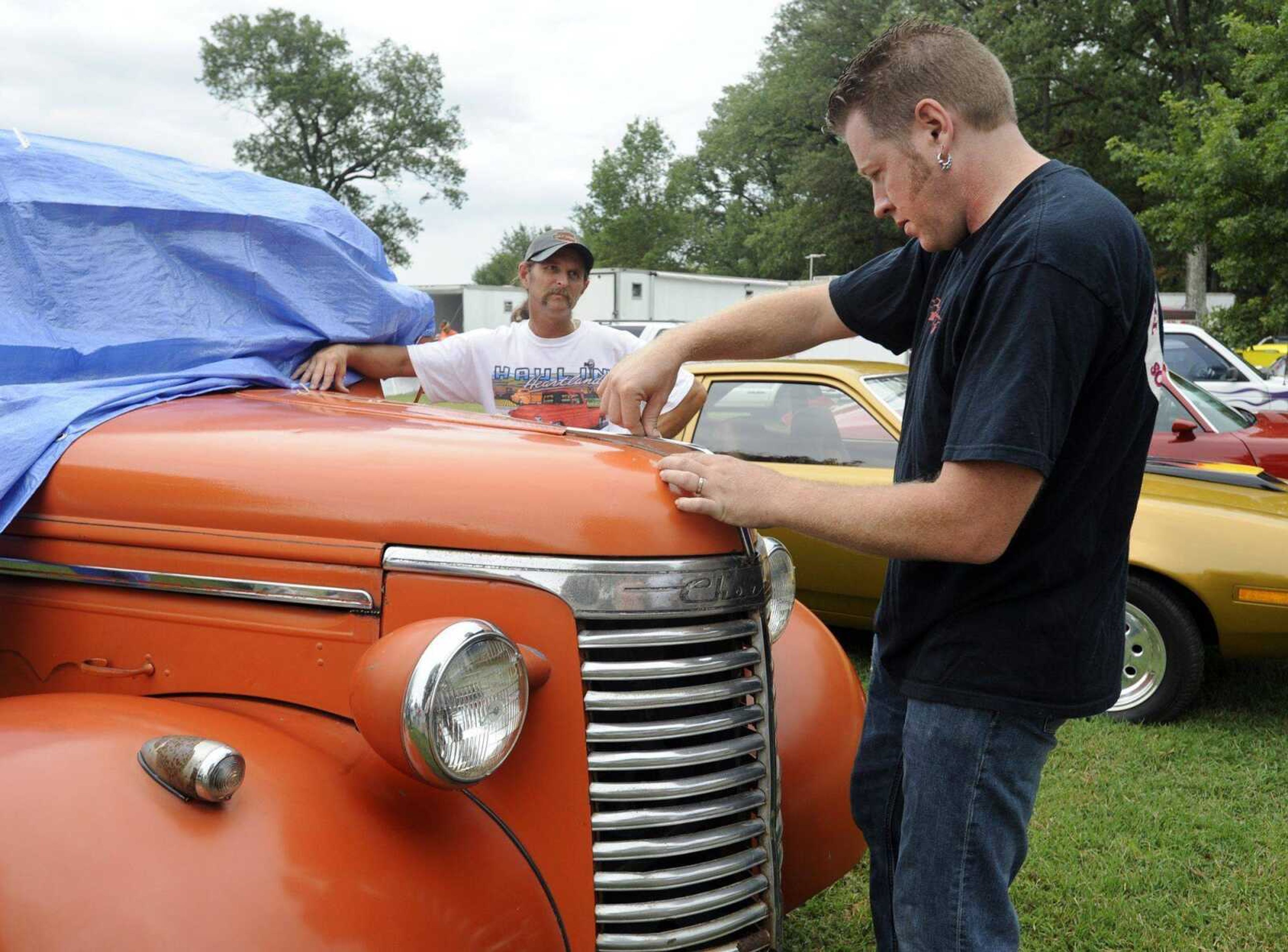 Rick Bacon works on pinstriping a 1940 Chevrolet pickup for Jimmy Erlbacher of Gordonville at the fifth annual MDA Motor Madness Cars for Kids show Saturday at Arena Park. Bacon is host of "MuscleCar" on Spike TV. (Fred Lynch)