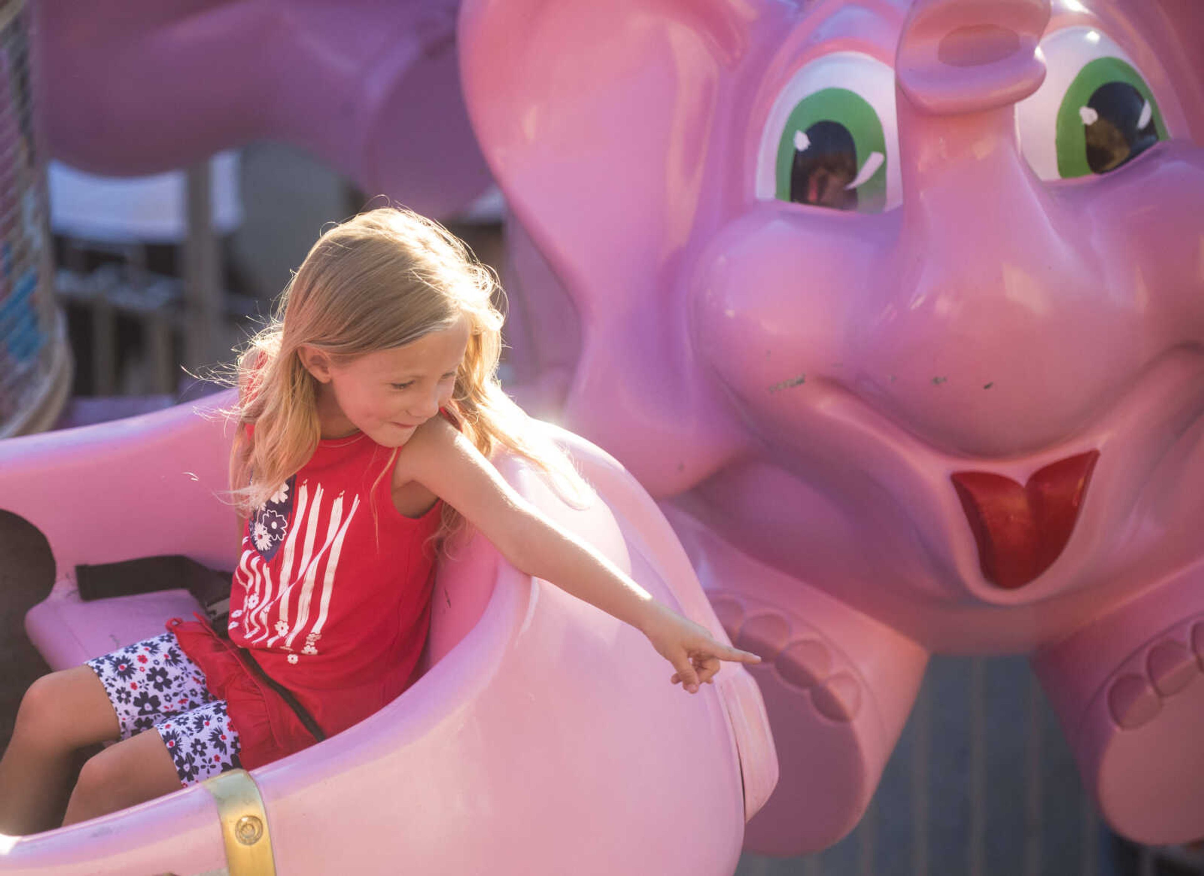 Jessie Jones, 5, points at her dad while she rides the flying elephants ride during the Jackson Homecomers Saturday, July 29, 2017 in Uptown Jackson.