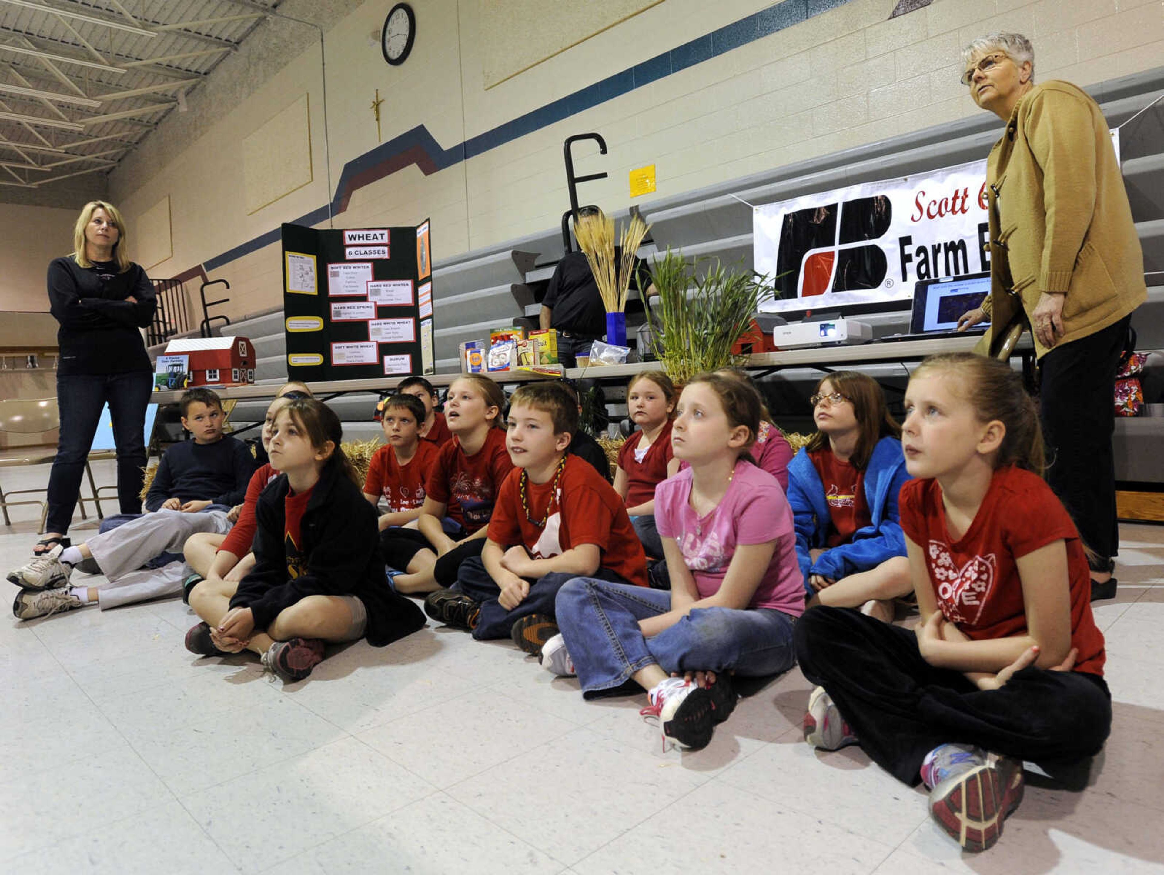 St. Ambrose third-grade students listen to a presentation by Vickie Westrich about wheat at the Scott County Farm Bureau display.