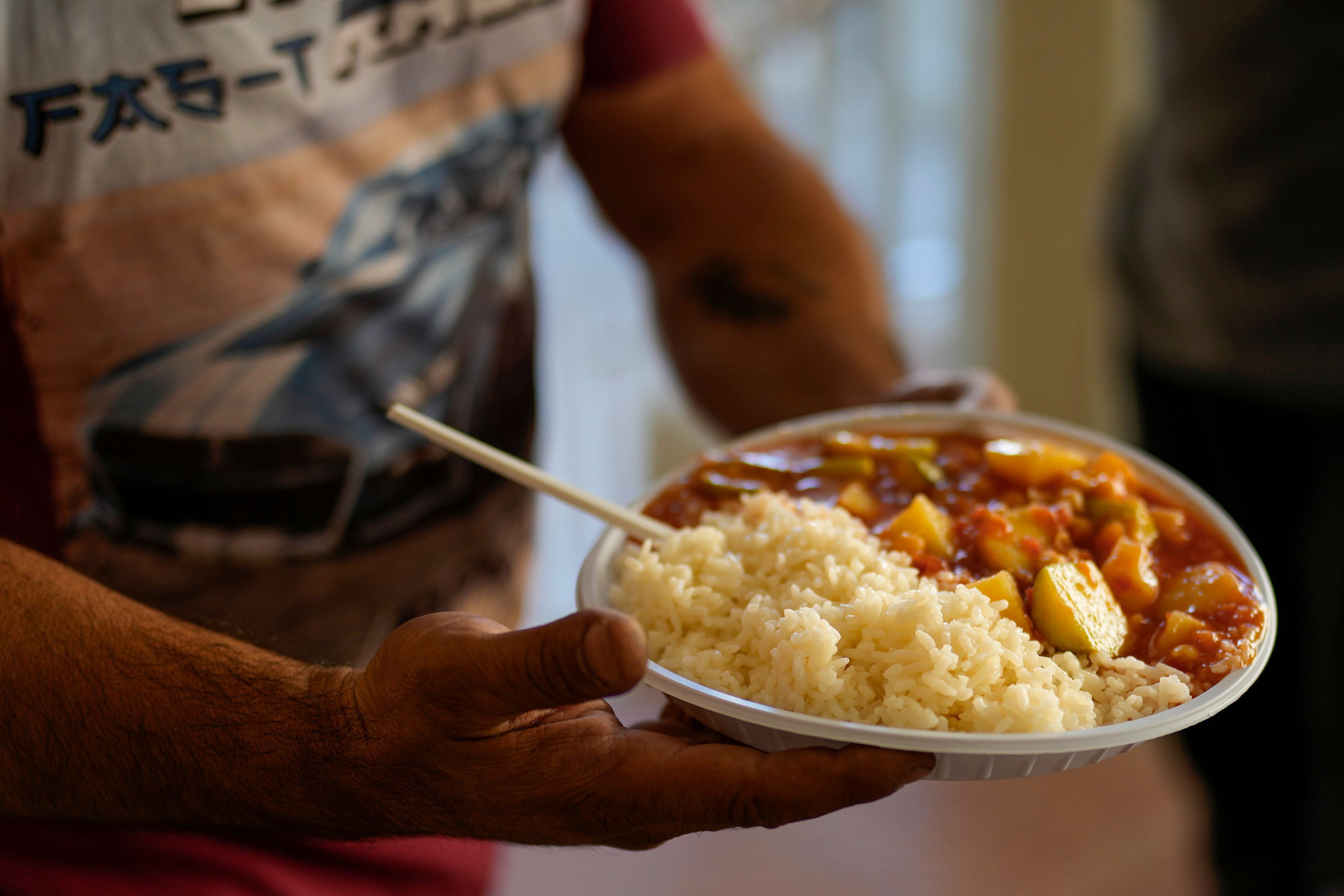 A displaced man who fled southern Lebanon with his family during the ongoing Hezbollah-Israel war holds a plate of food at a school in the village of Ebrine, northern Lebanon, Thursday, Oct. 24, 2024. (AP Photo/Hassan Ammar) (AP Photo/Hassan Ammar)