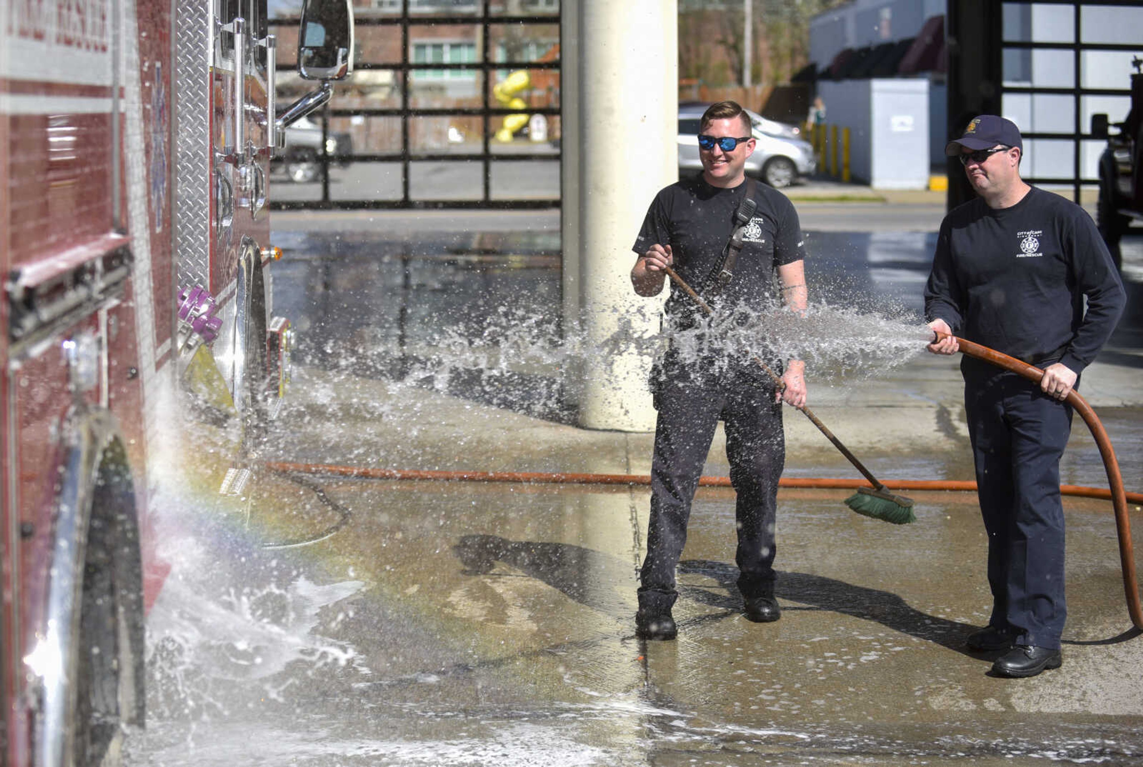 Cape Girardeau firefighter David Uptmor, center, smiles as fire captain Shawn Morris washes Engine 1 on Tuesday, April 17, 2018, at Cape Girardeau Fire Station No. 1 in Cape Girardeau.