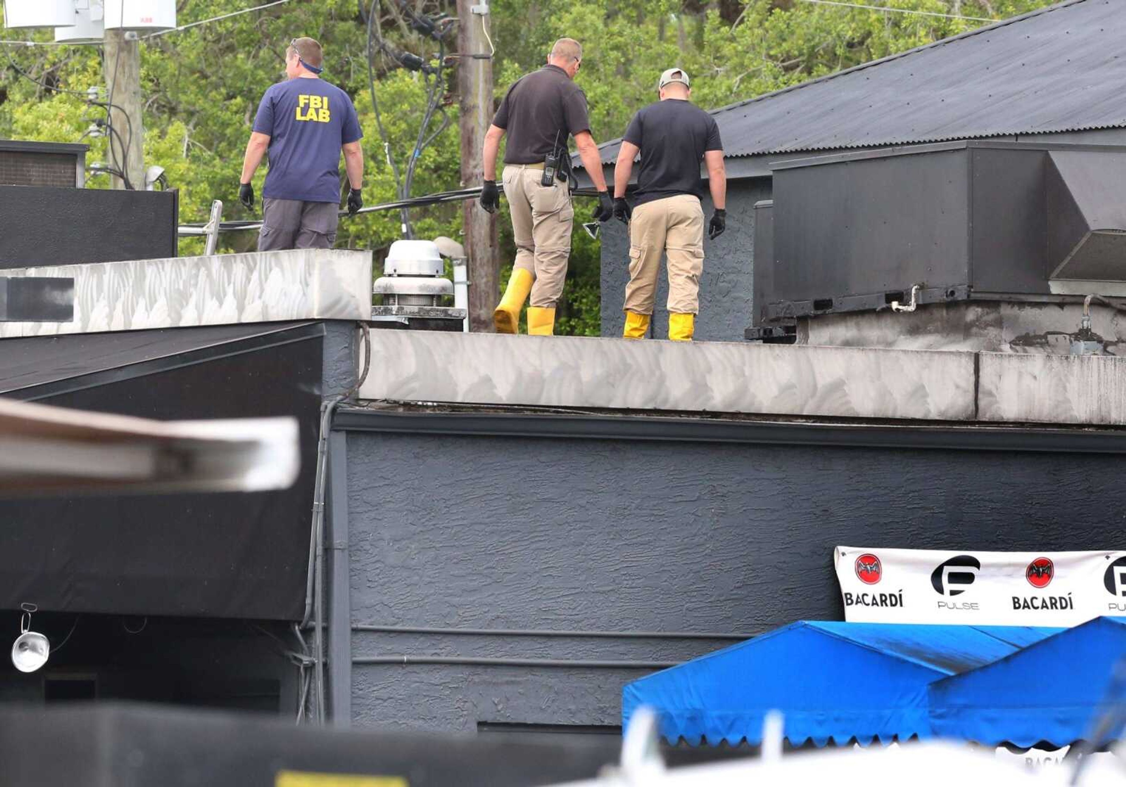 FBI personnel walk on the roof Monday of the Pulse nightclub, investigating the mass-shooting scene in Orlando.