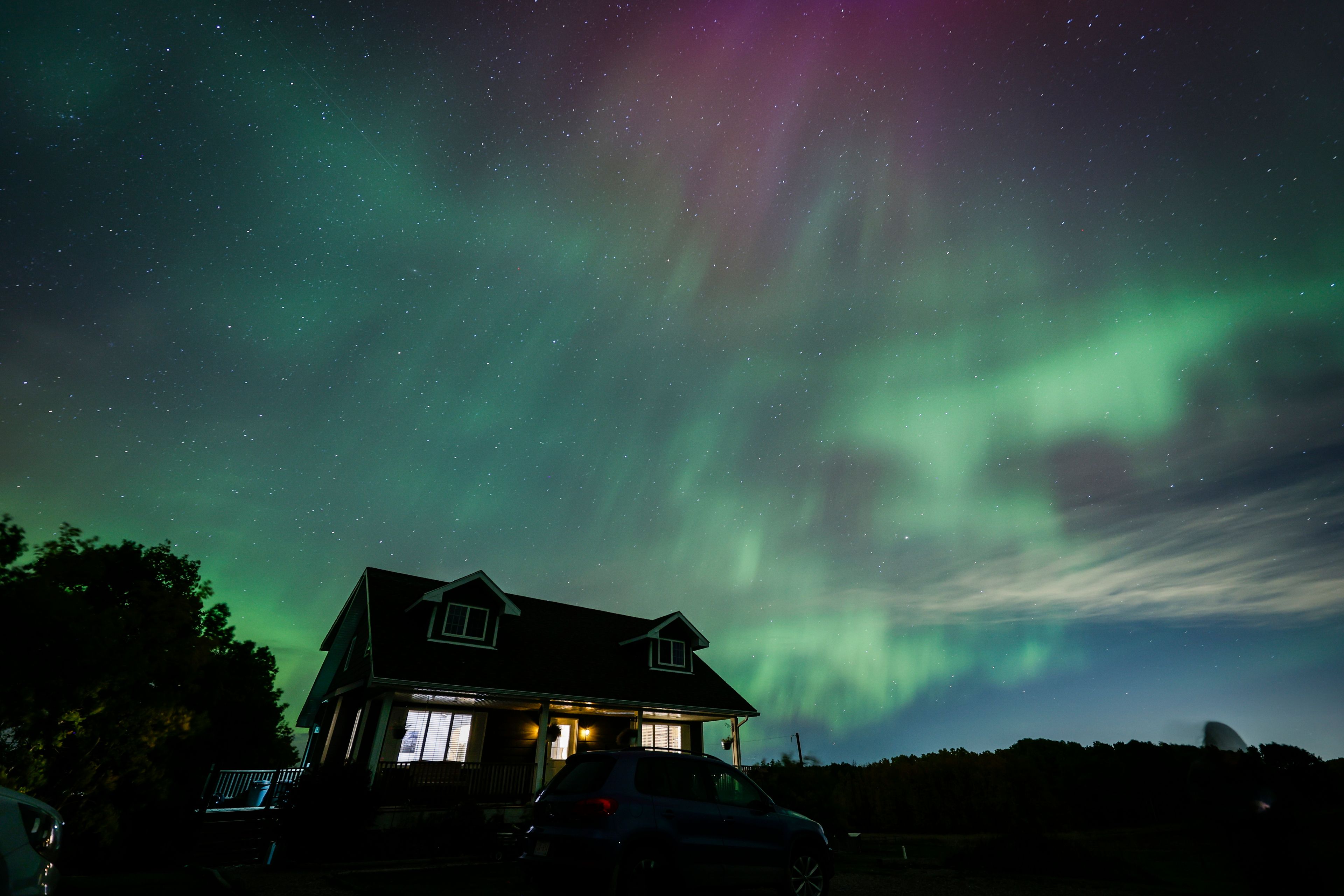 An aurora borealis, also known as the northern lights, is seen over a home near Cremona, Alberta, Monday, Oct. 7, 2024. (Jeff McIntosh/The Canadian Press via AP)