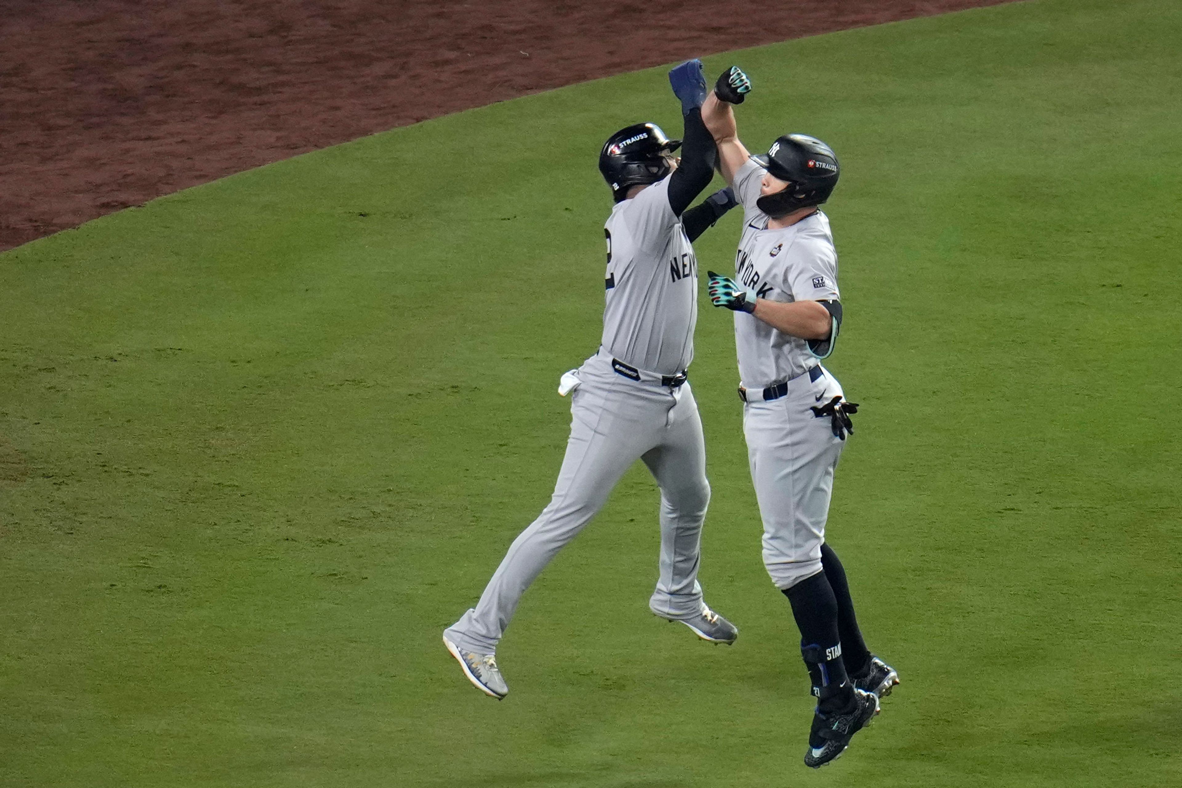 New York Yankees' Giancarlo Stanton, right, celebrates with Juan Soto after both scored on Stanton's two-run home run against the Los Angeles Dodgers during the sixth inning in Game 1 of the baseball World Series, Friday, Oct. 25, 2024, in Los Angeles. (AP Photo/Julio Cortez)