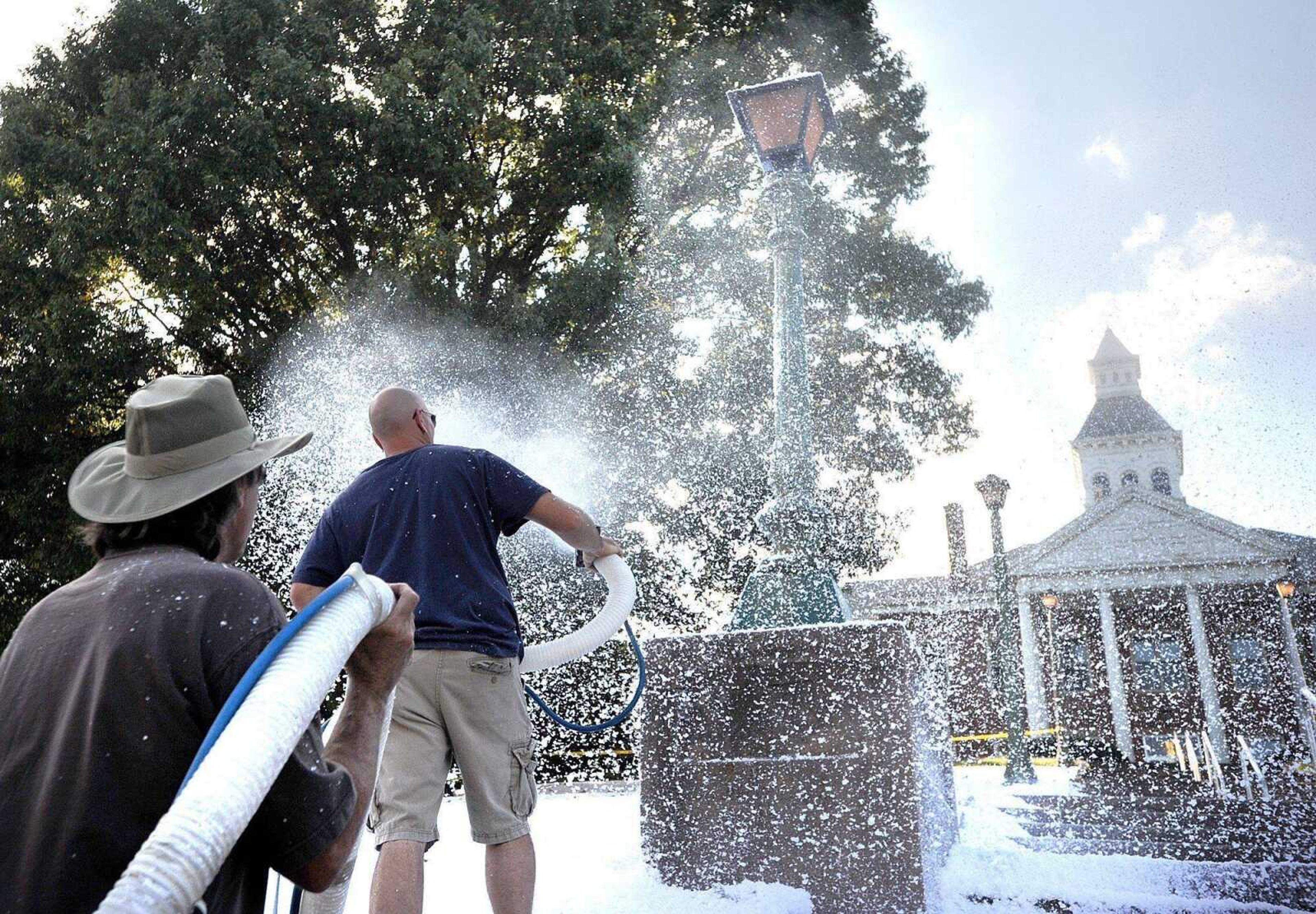 "Gone Girl" film crew members spray fake snow on the lawn and steps of the Common Pleas Courthouse on Oct. 11 in Cape Girardeau. More images are in a gallery at semissourian.com. (Laura Simon)