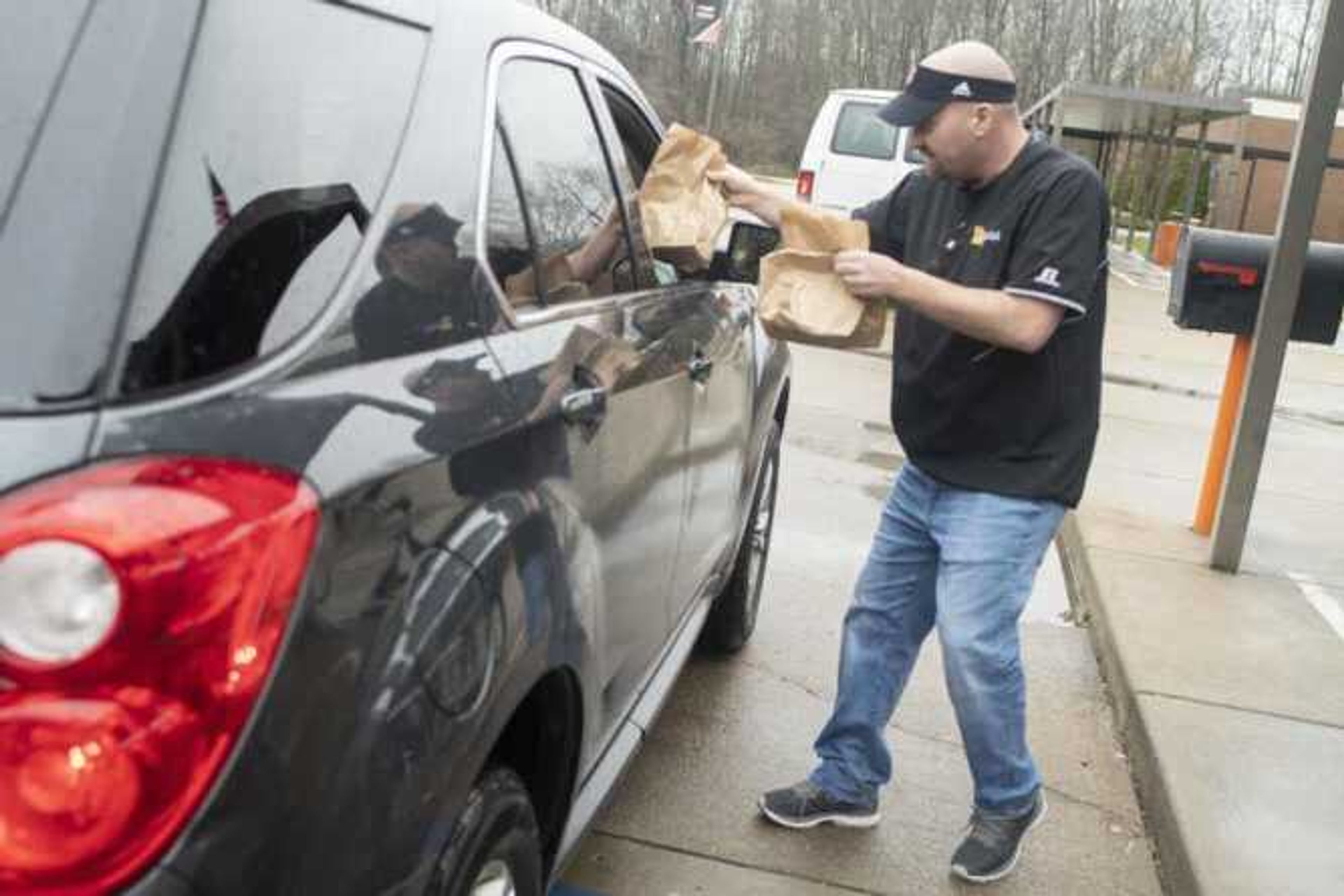 Cape Central High School athletic director Tyson Moyers hands out food for those 18 years old and younger Wednesday at Clippard Elementary in Cape Girardeau.