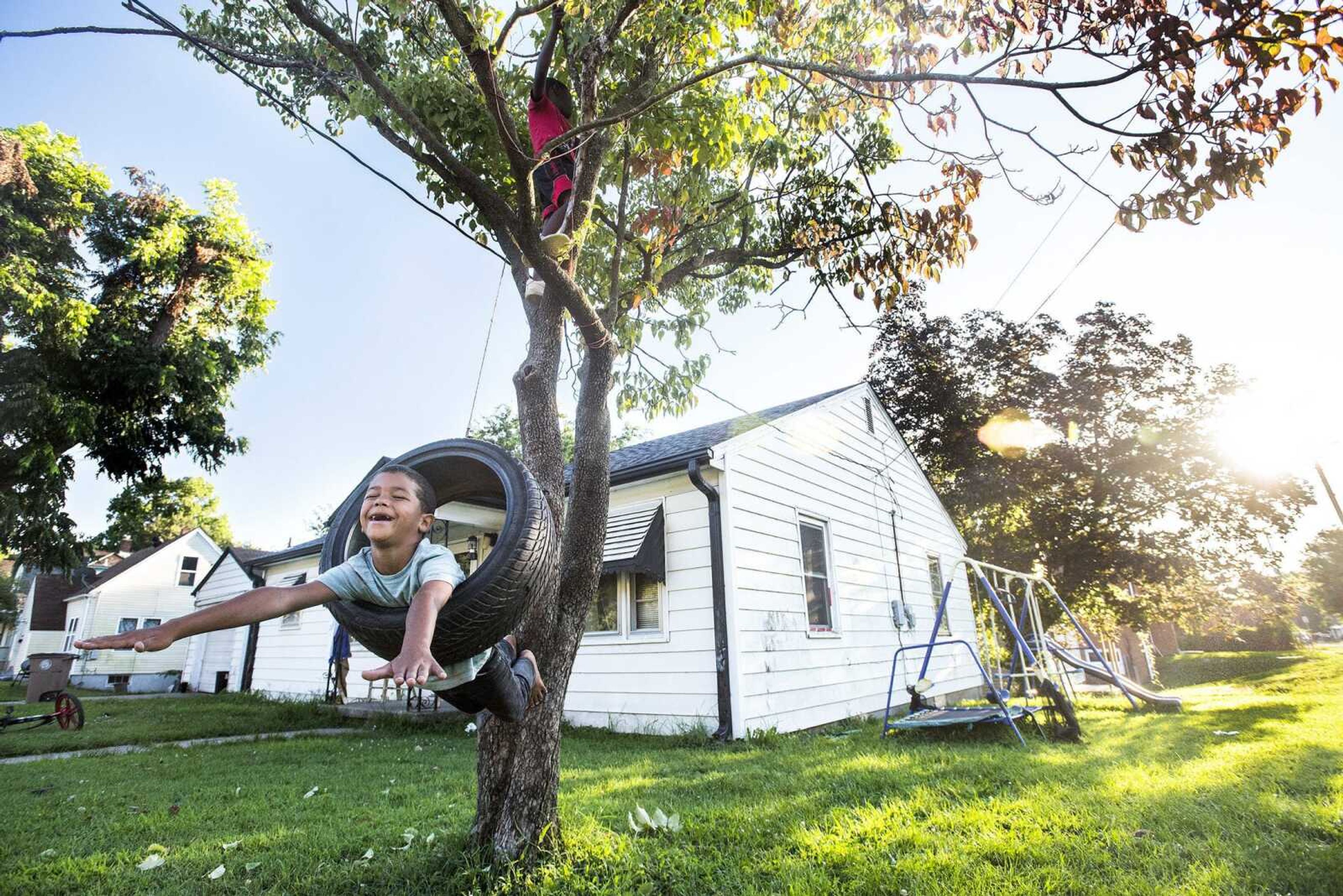 Briton Purl, 7, hangs from a tire swing in his front yard while his friend, Kaiden Thompson, 6, climbs above him Aug. 1 in Cape Girardeau.