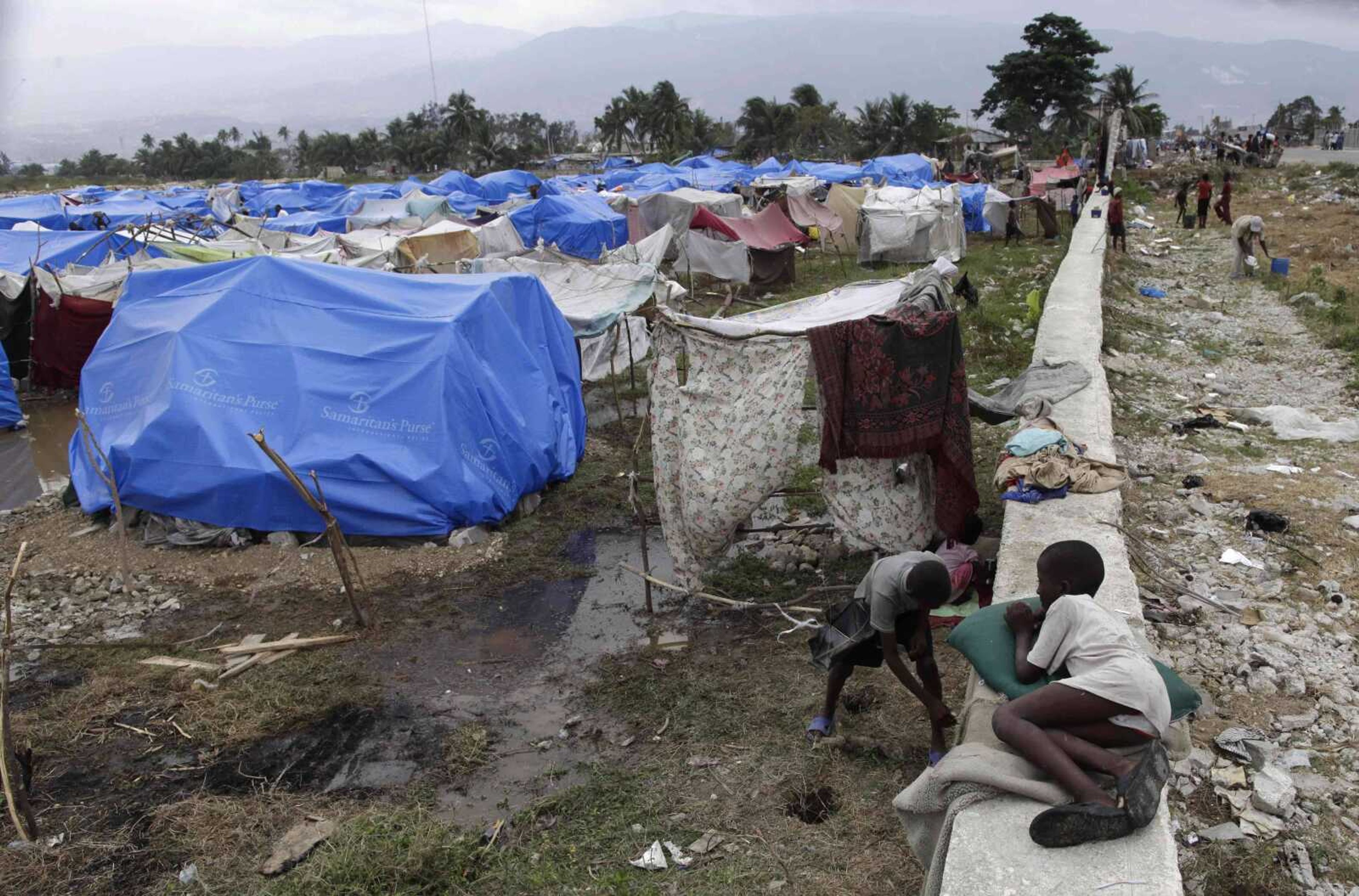 A child lies on the wall of a makeshift camp for homeless earthquake survivors Thursday in Port-au-Prince, Haiti. Relief officials are scrambling to move more than 1.2 million quake victims out of overcrowded makeshift camps before the start of the rainy season. (Ramon Espinosa ~ Associated Press)