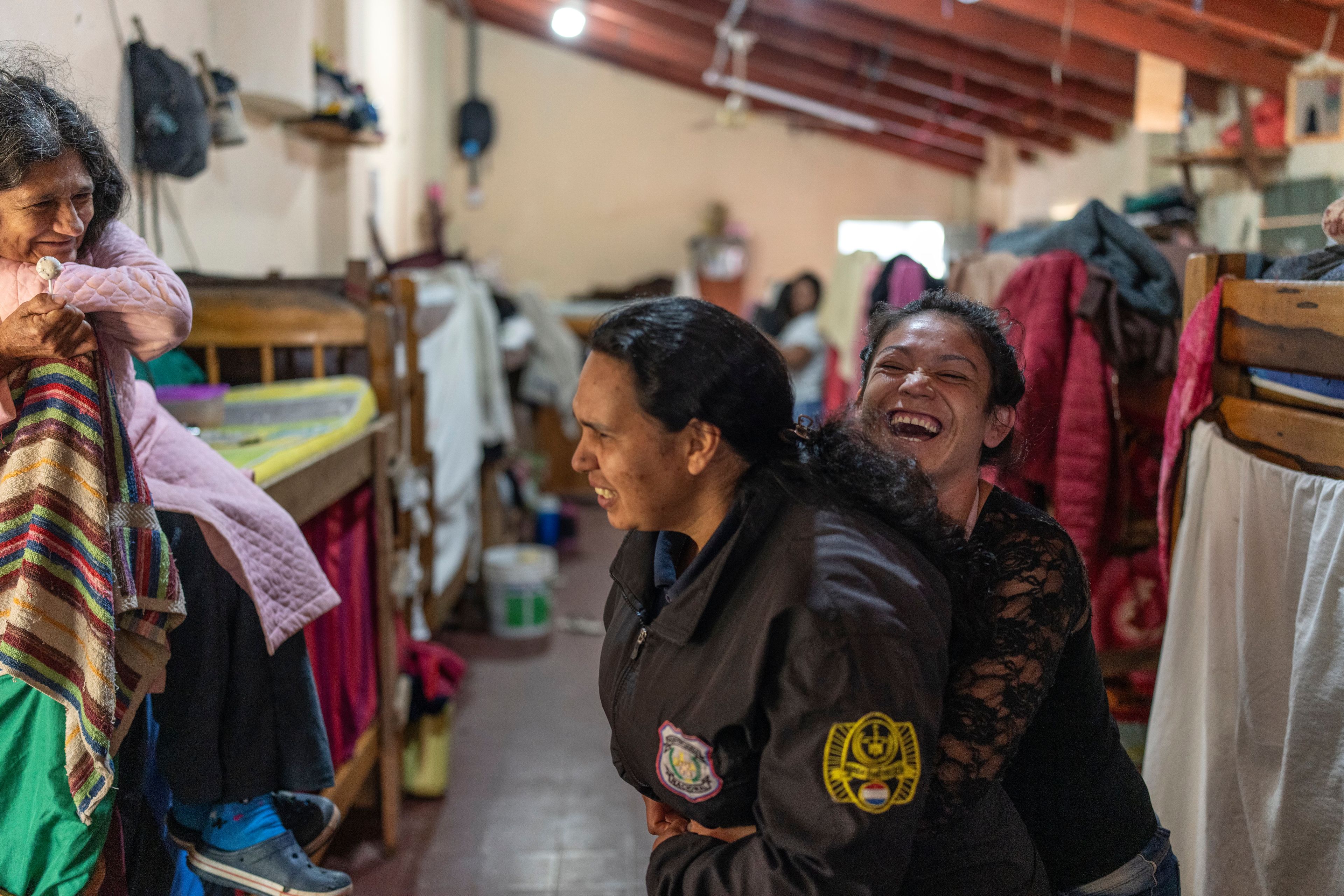 A prisoner, right, playfully hugs a female prison guard at the women's pavilion of the Regional Penitentiary in Villarica, Paraguay, Sunday, Sept. 1, 2024. (AP Photo/Rodrigo Abd)