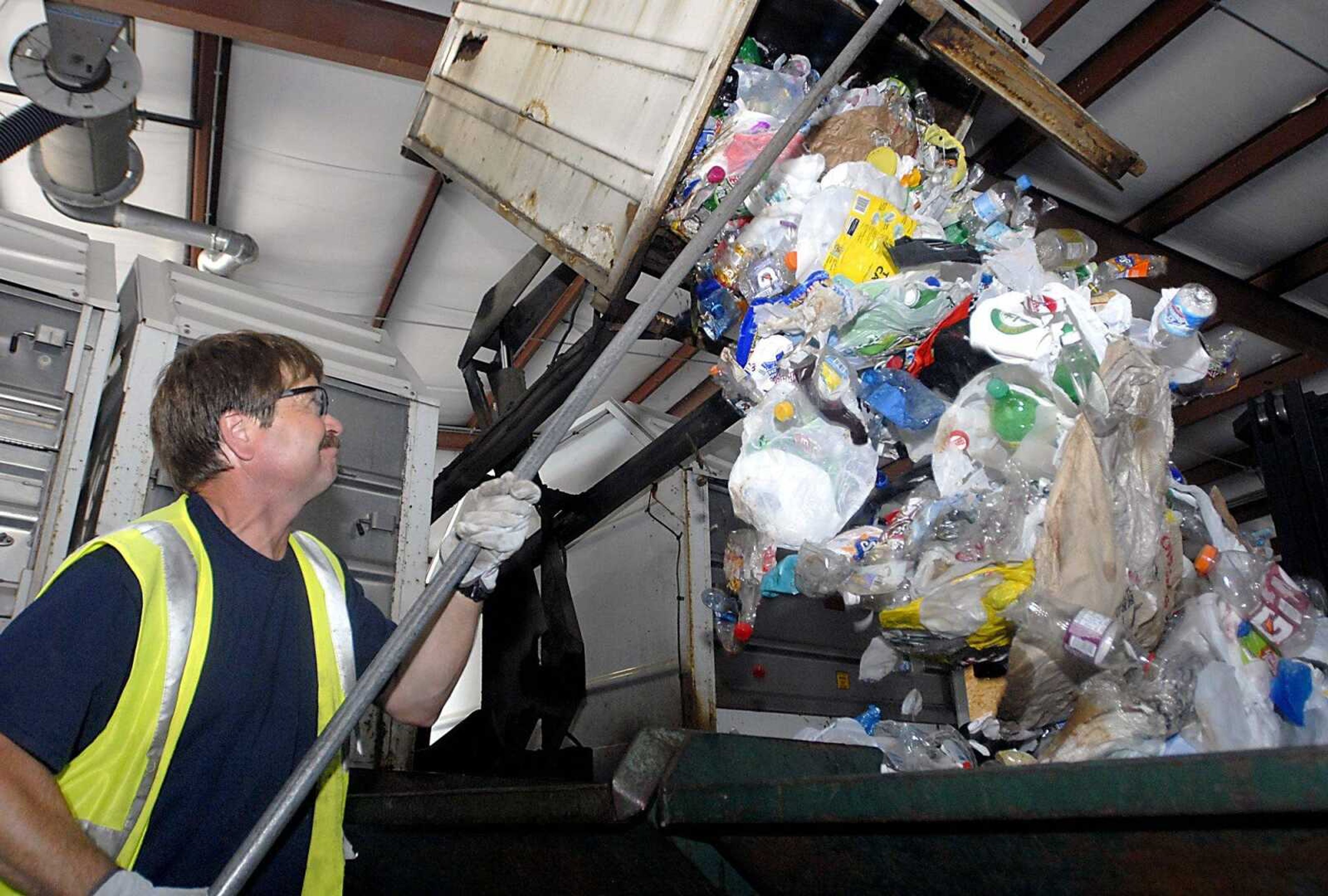 City employee Rob Reed helps empty a compacted container of plastic Friday, July 24, 2009, from a recycle collection truck at the Recycle Center in Cape Girardeau.  A new trash and recycle program would no longer require recyclables to be separated. (Kit Doyle)