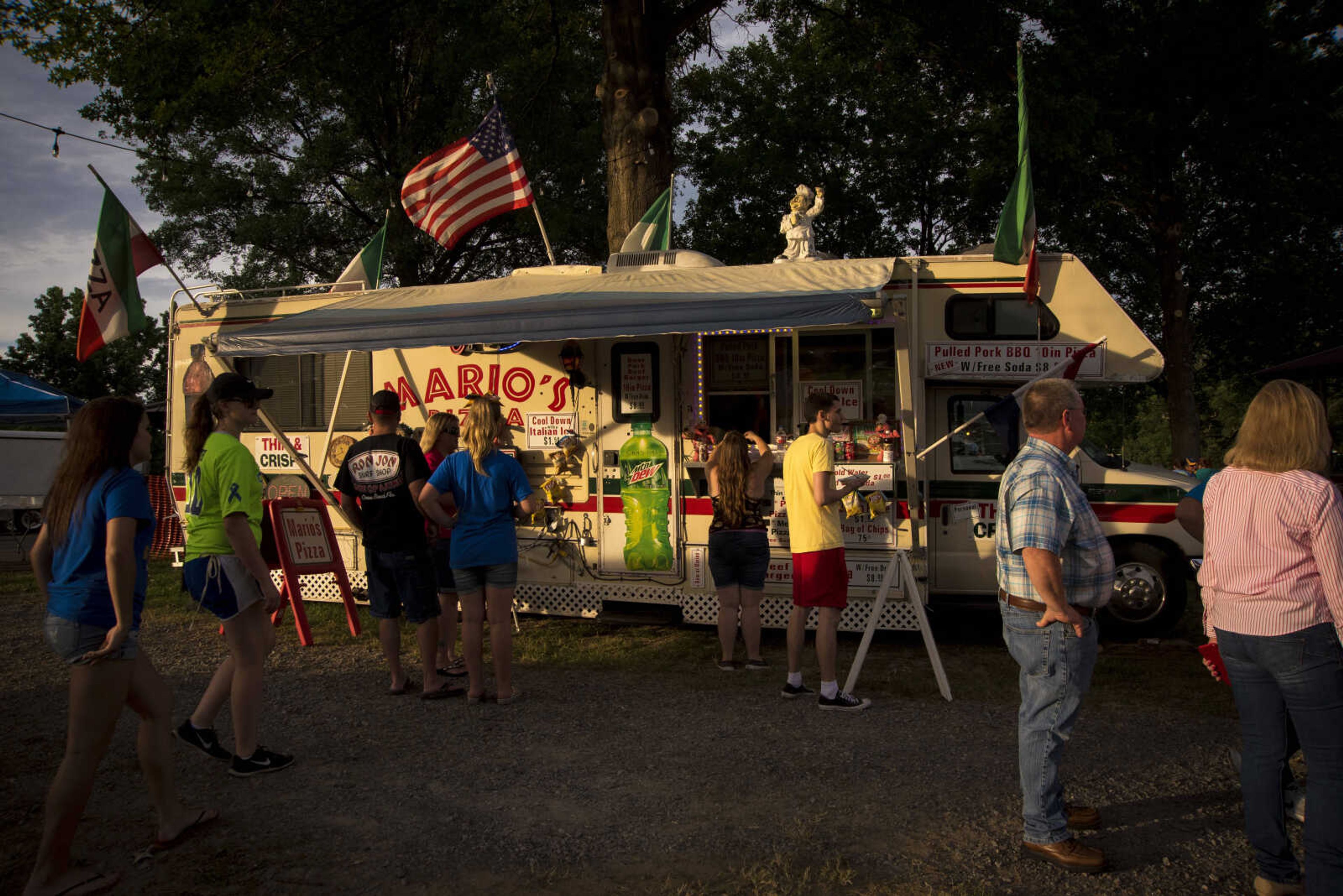 People wait in line for Mario's food truck during the 41st annual Mid-Summer Festival Friday, June 16, 2017 at Scott City Park.