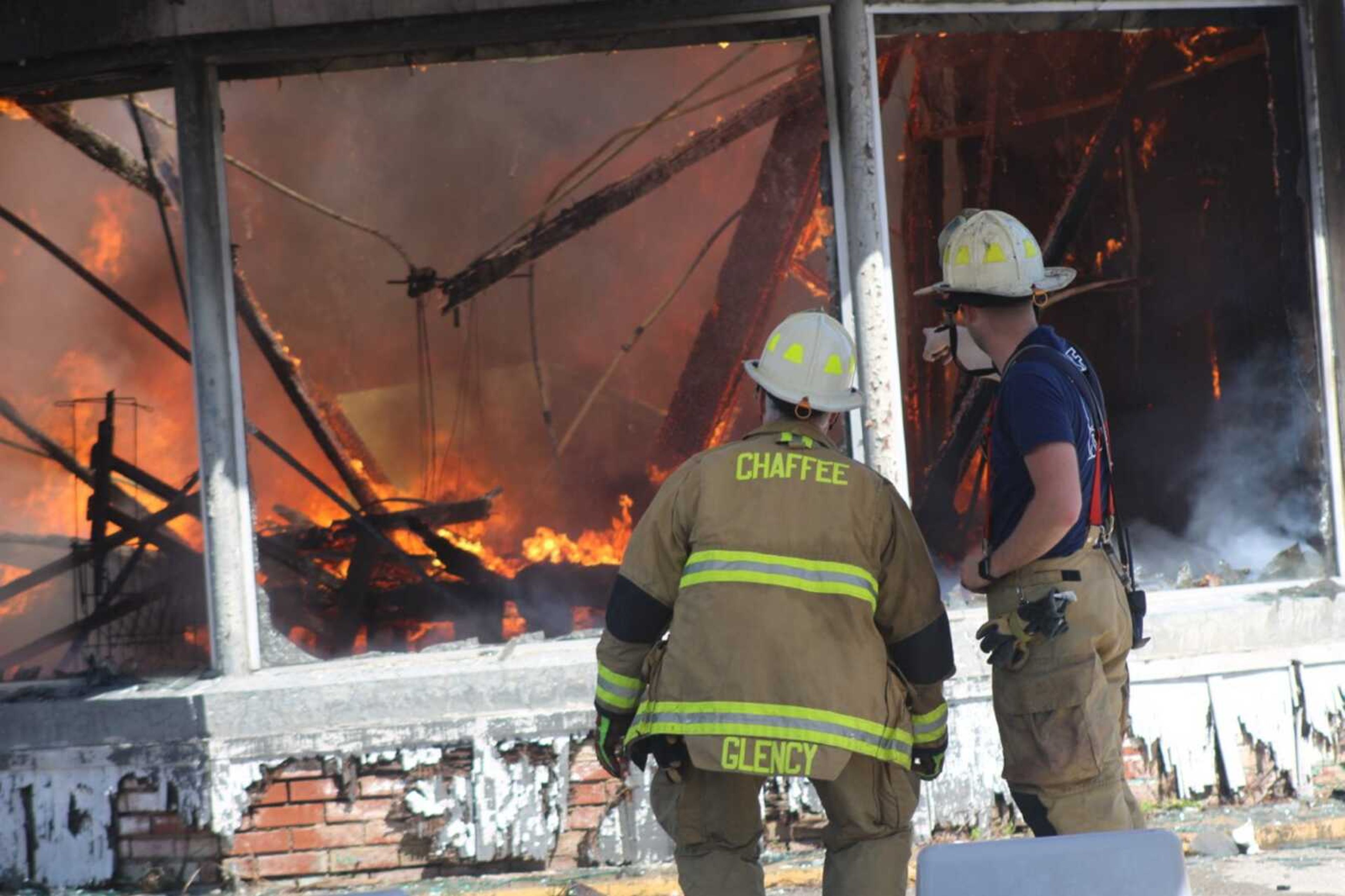 Chaffee, Missouri, volunteer fire chief Sam Gelcy and Cody Johnson observe the fire as the old Sinclair gas station is burned April 2 in Chaffee.