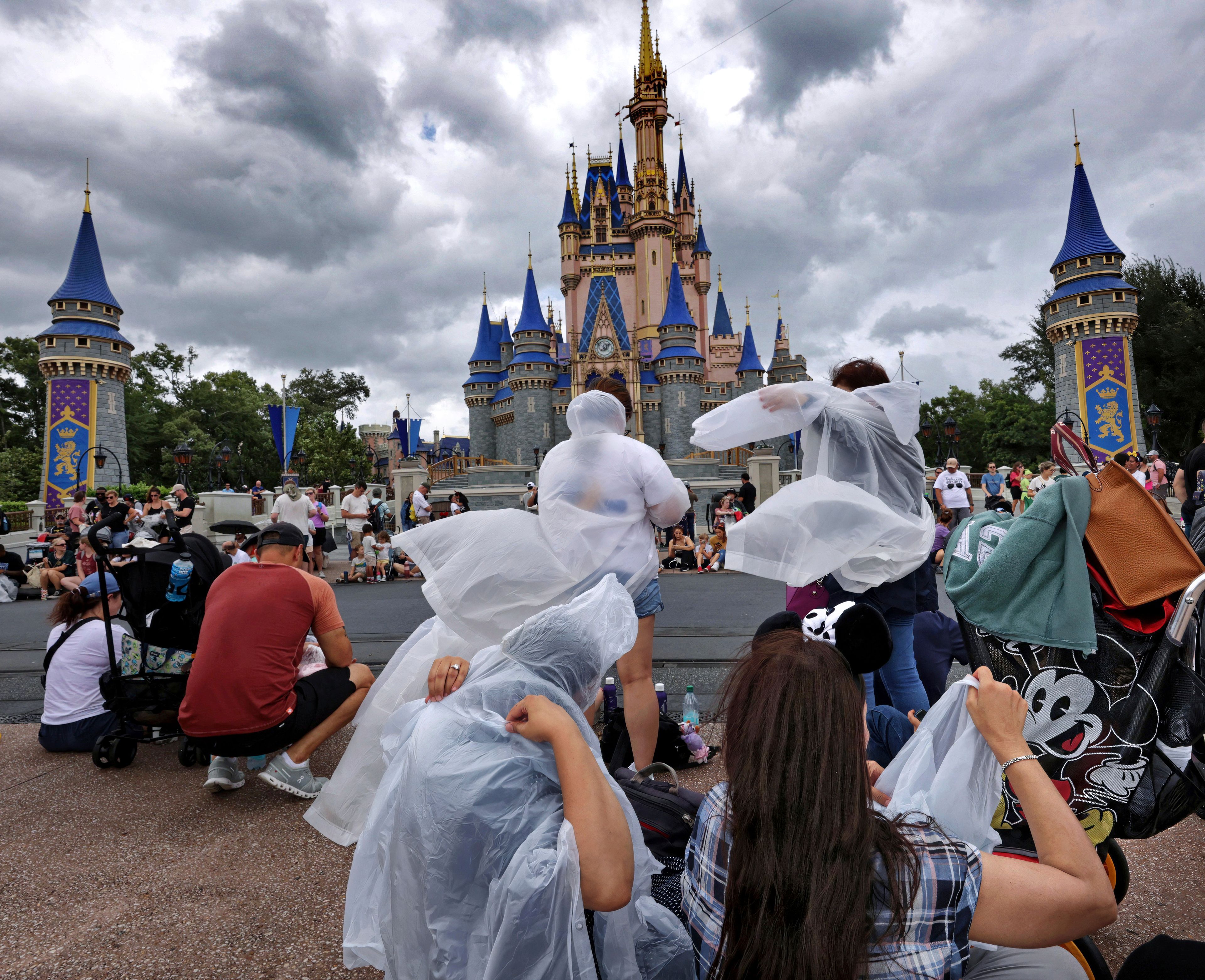 Guests at the Magic Kingdom break out ponchos at Cinderella Castle as bands of weather from Hurricane Helene move through Walt Disney World in Bay Lake, Fla., Thursday, Sept. 26, 2024. All four of Disney's Florida theme parks remained open Thursday as the storm passed to the west in the Gulf of Mexico. (Joe Burbank/Orlando Sentinel via AP)