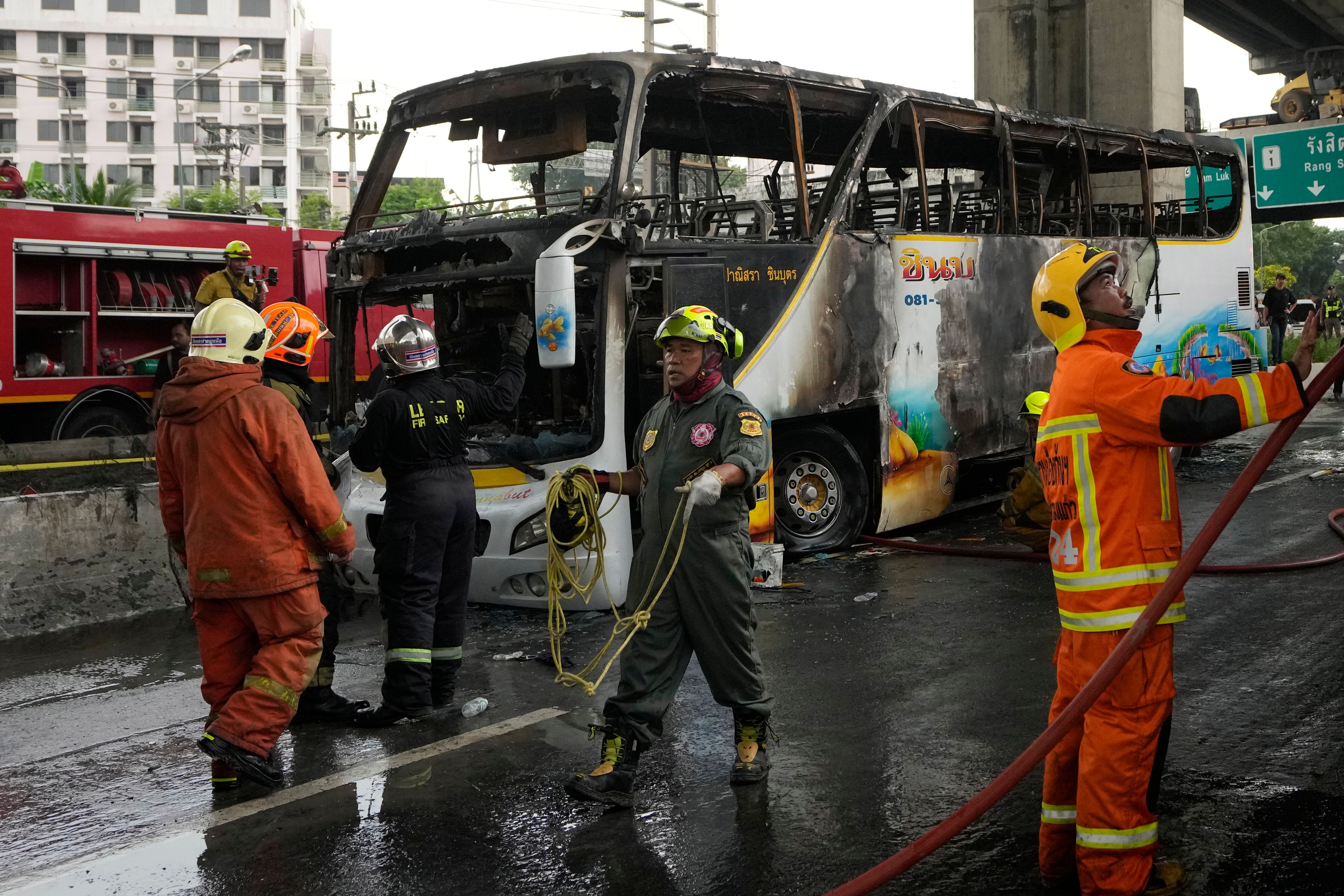 Rescuers work at the site of a bus that caught fire, carrying young students with their teachers, in suburban Bangkok, Tuesday, Oct. 1, 2024. (AP Photo/Sakchai Lalit)