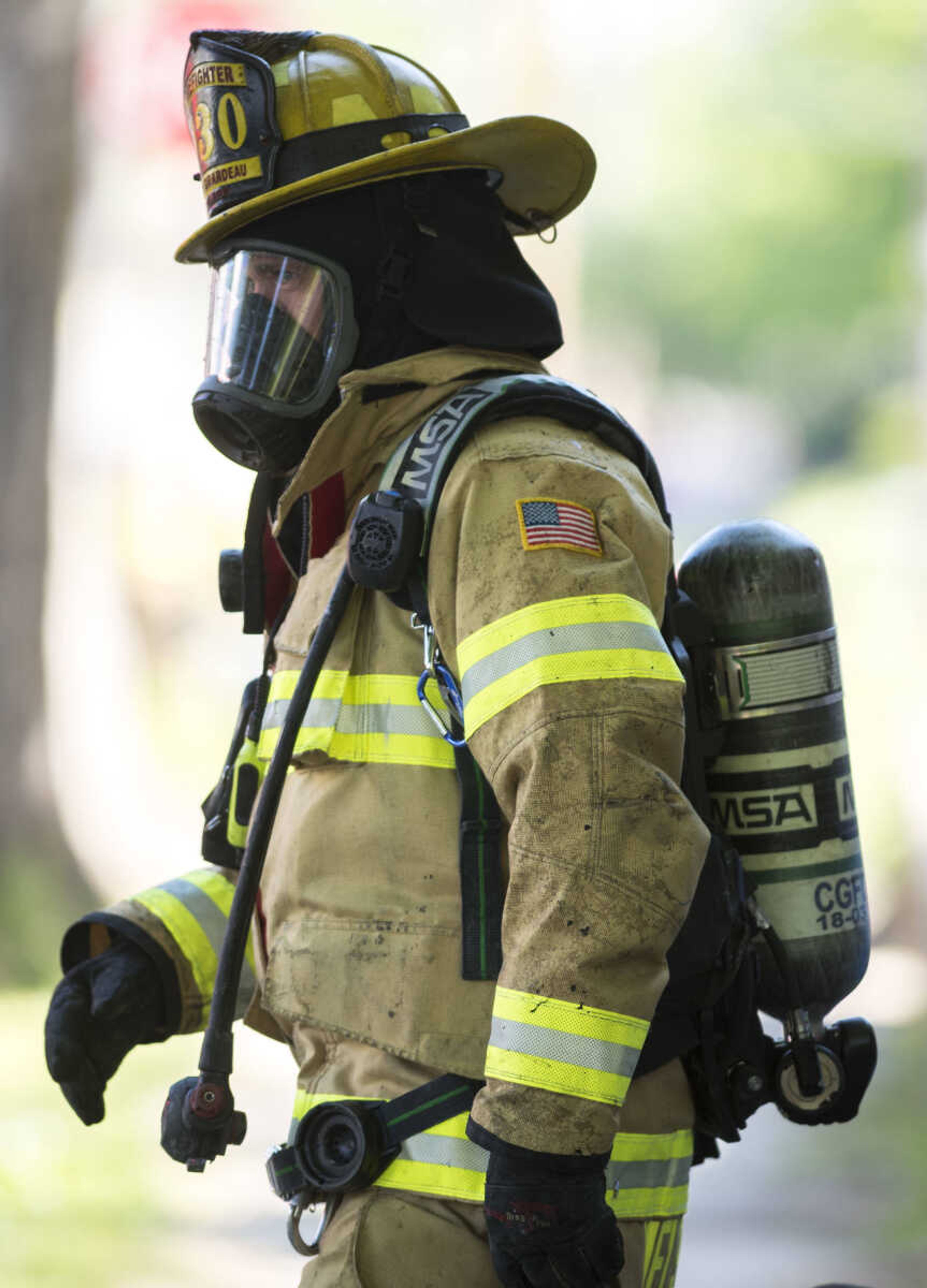 Cape Girardeau firefighter Wilie Nelson responds to the scene of a structure fire Monday, May 11, 2020, at 40 North Henderson Ave. in Cape Girardeau.